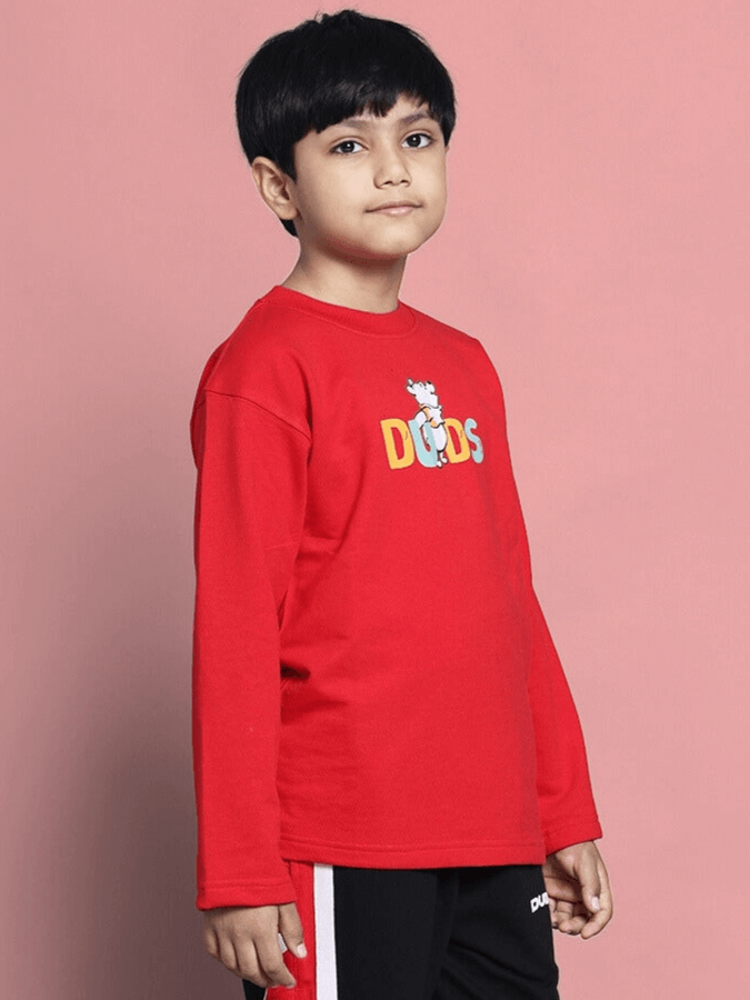 Child wearing WINNIE oversized red sweatshirt by DUDS, featuring a colorful logo, ideal for boys and girls. Tailor-made for comfort.