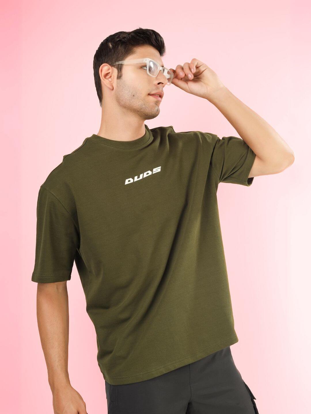 Man wearing AMOUR OVER-SIZED T-SHIRT OLIVE GREEN, premium cotton French terry fabric, stylish casual wear for men.