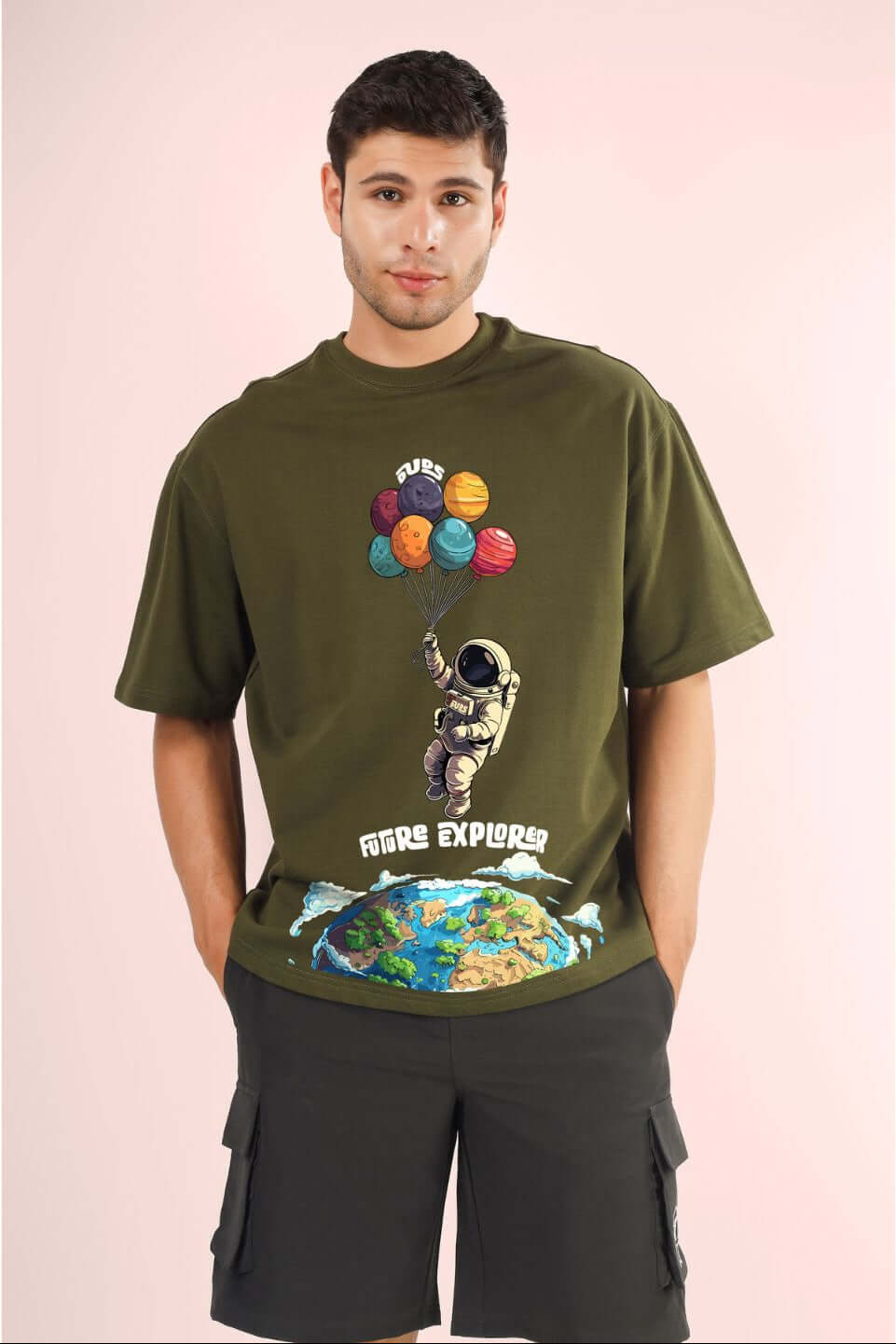 Model wearing FUTURE EXPLORER OVERSIZED T-SHIRT OLIVE GREEN with astronaut graphic.
