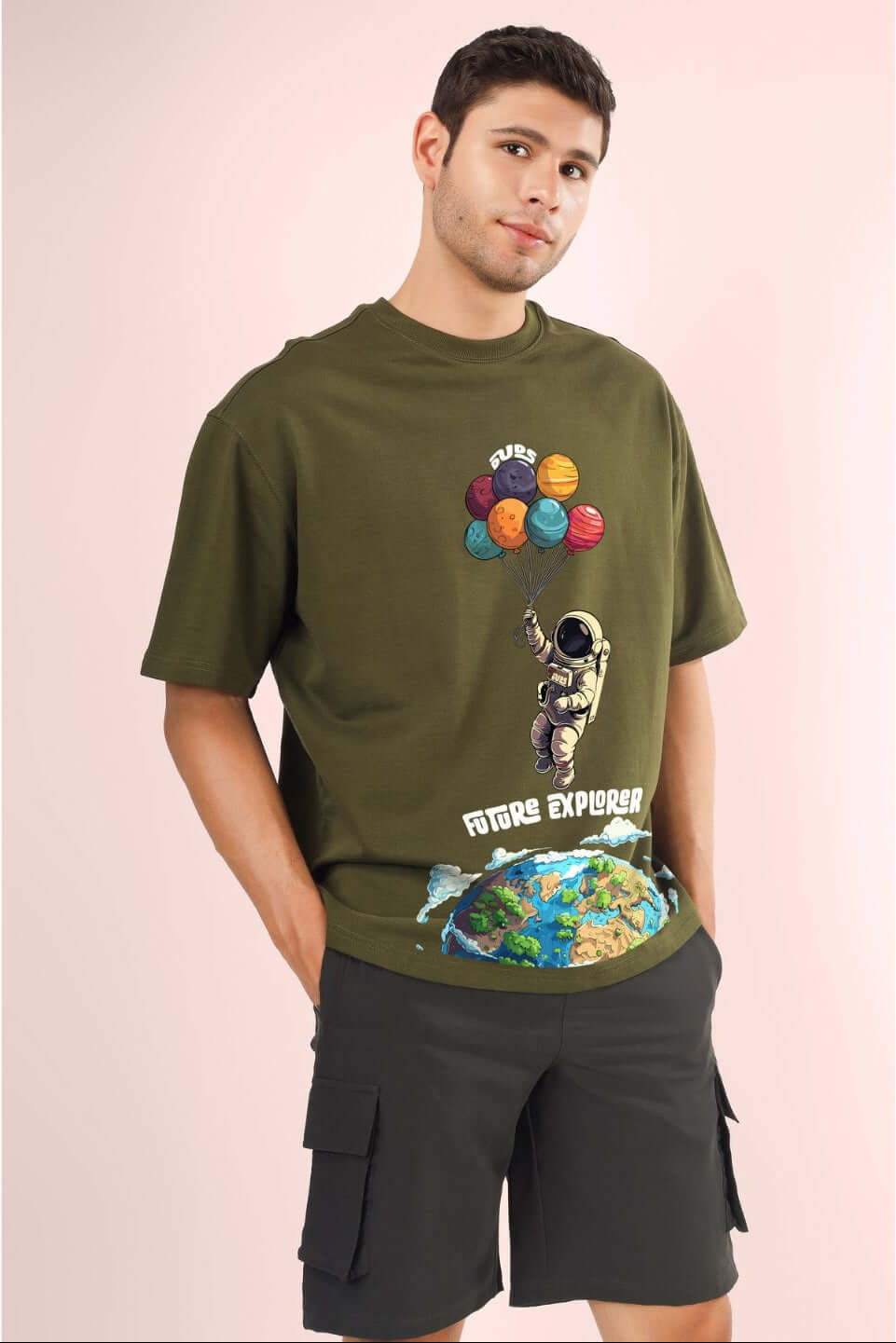 Model wearing FUTURE EXPLORER OVERSIZED T-SHIRT OLIVE GREEN with astronaut graphic.