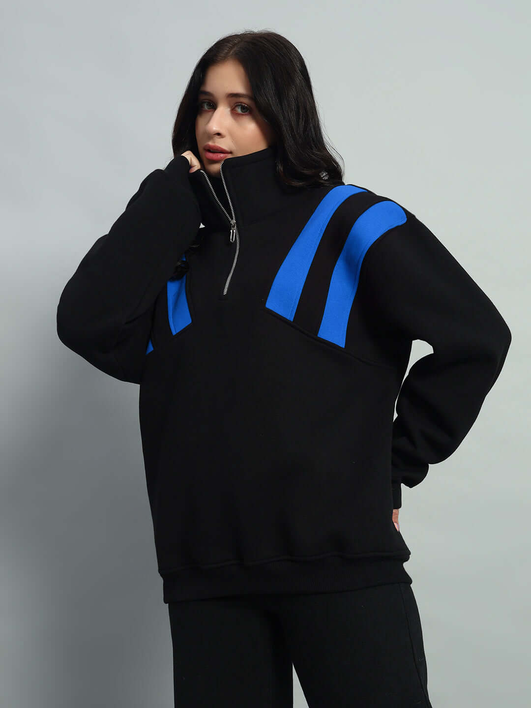 Black and blue women's colorblock fleece jacket with crossbar design, worn by model; zipper details, casual style.