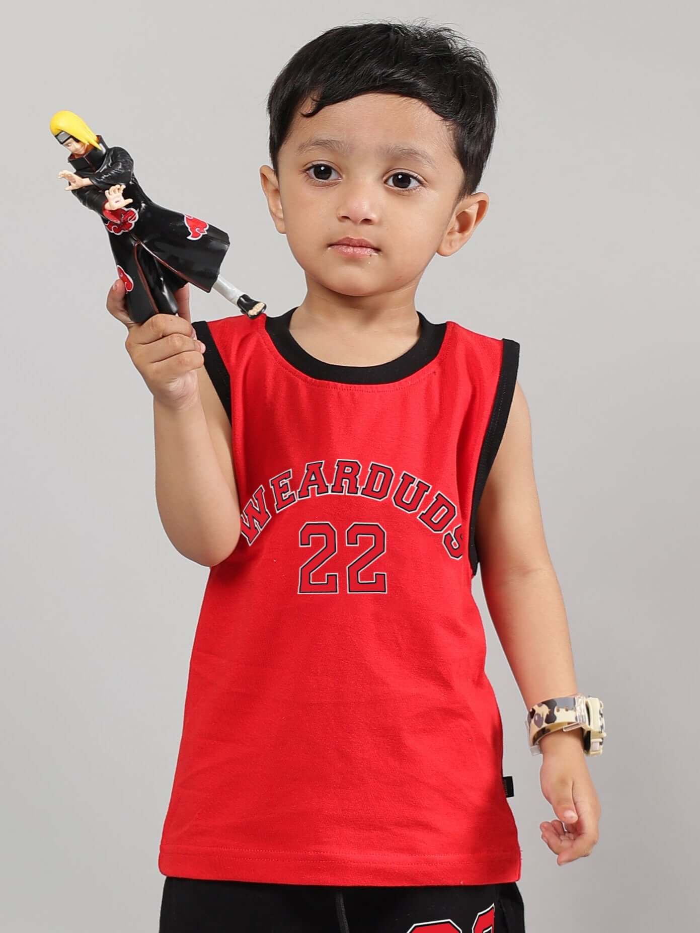 Young child wearing a red AMIGA T-shirt for boys and girls, holding a toy, showcasing DUDS quality craftsmanship.