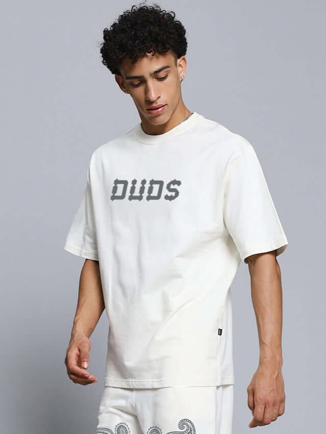 Model wearing off-white oversized T-shirt with paisley print, 97% premium cotton French terry. Fashion by Color By Colours, made in India.