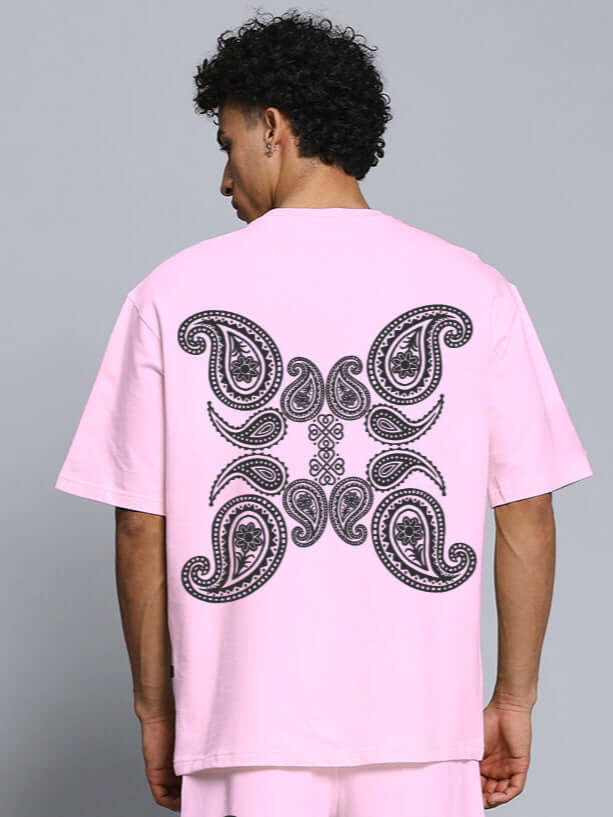 Back view of a pink oversized t-shirt featuring a paisley print, made from premium cotton fabric, ideal for casual wear.