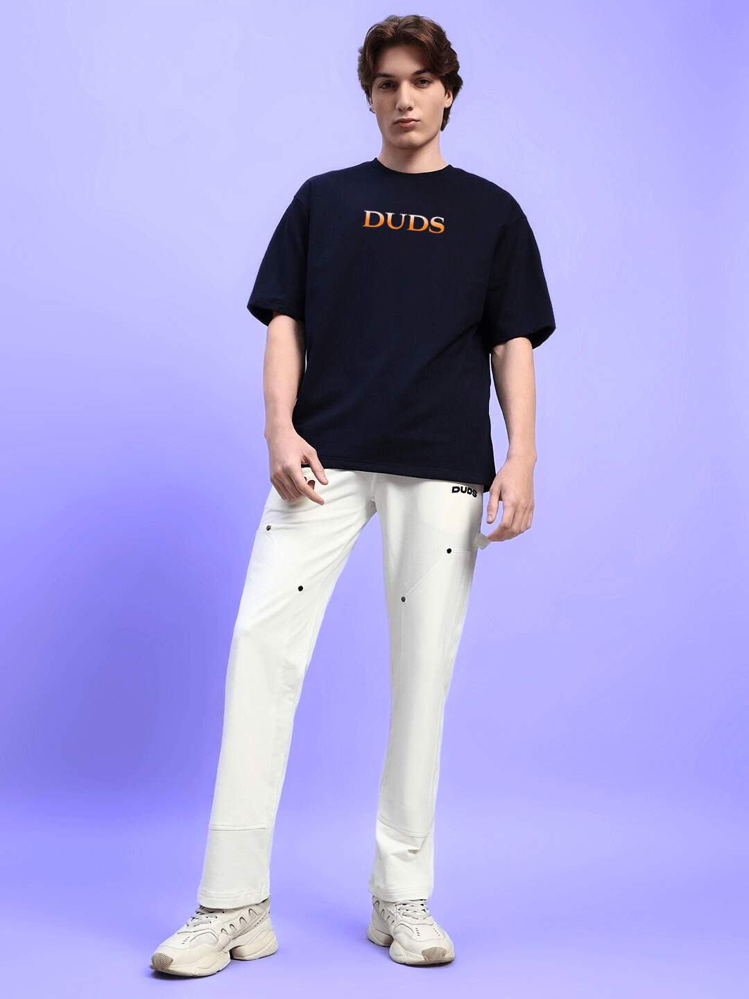 Model wearing HIDDEN POWER PRINTED OVERSIZED T-SHIRT BLACK in relaxed streetwear style against a purple background.