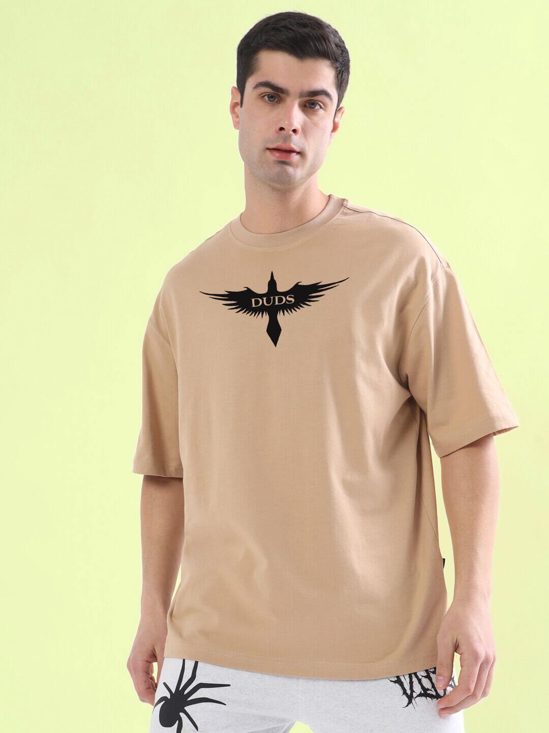 Man wearing SILENT BUT POWERFUL PRINTED T-SHIRT BEIGE with black graphic design