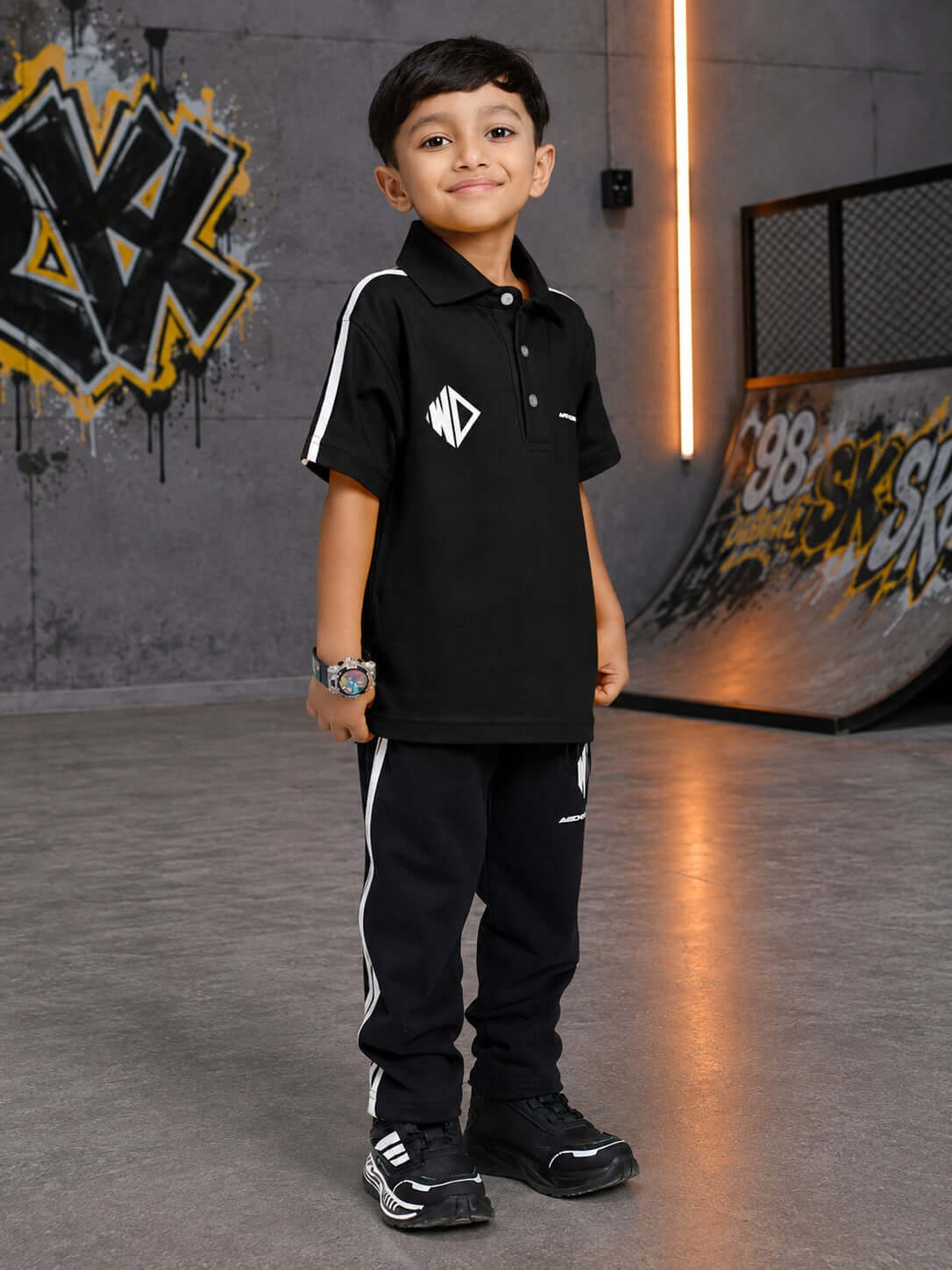 CHAMPION TRACK POLO CO-ORD FOR BOYS GIRLS BLACK worn by a boy in a stylish urban setting.