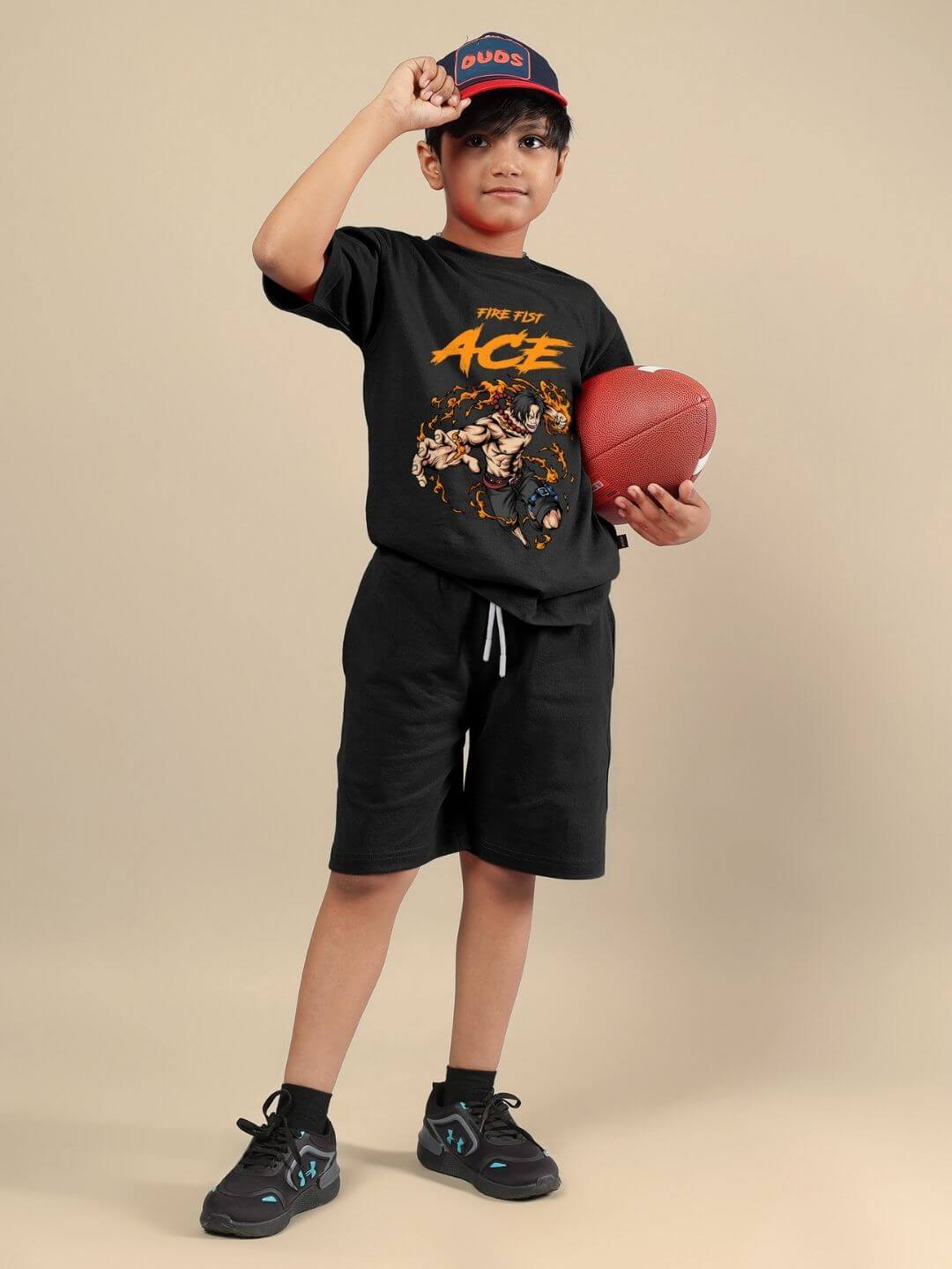 Child wearing ACE co-ord set in black, holding a football, showcasing fashion and comfort for boys and girls.