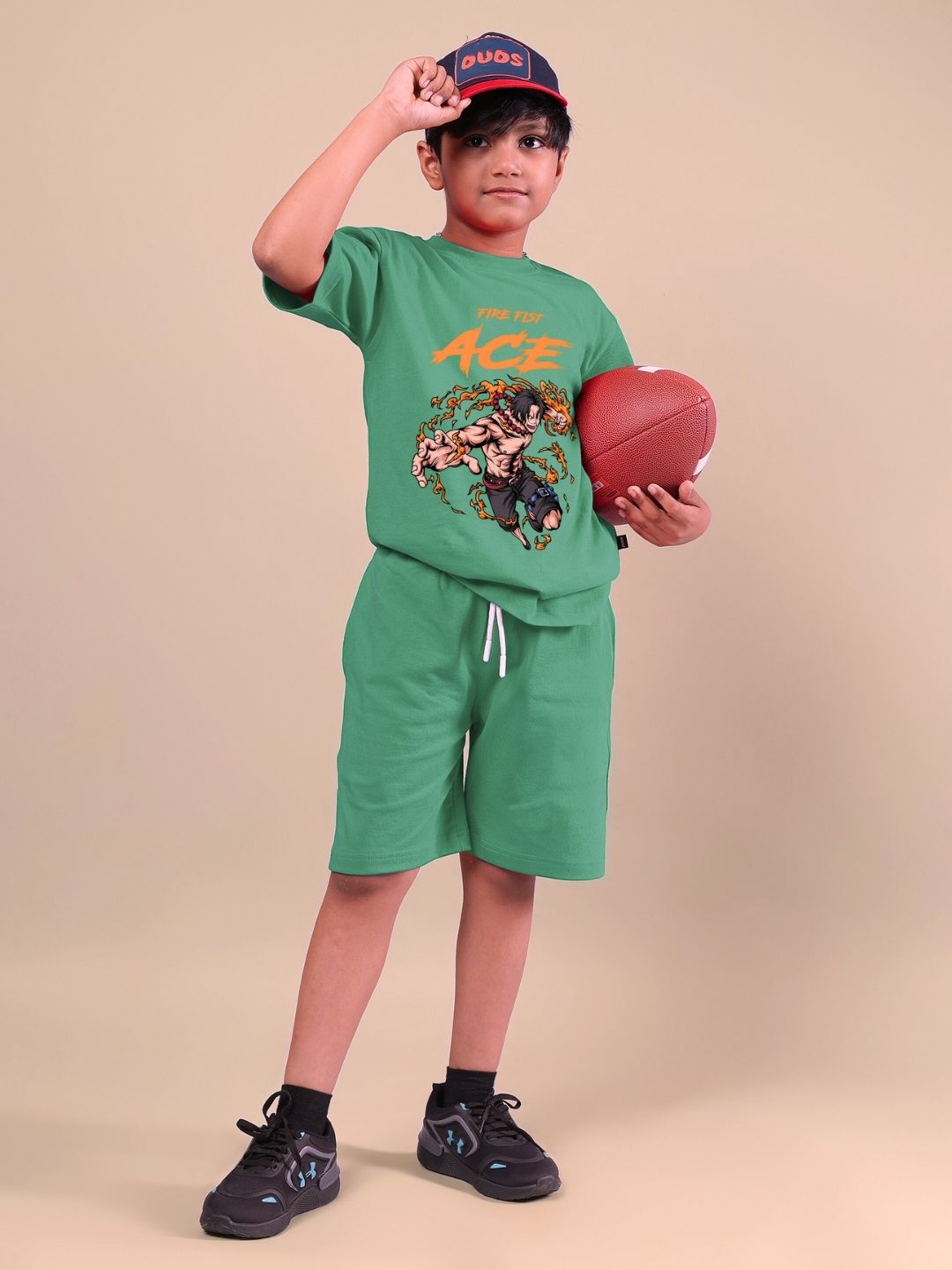 Child wearing green ACE co-ord set, featuring graphic t-shirt and shorts, holding a football, ideal for boys and girls who love bold fashion.