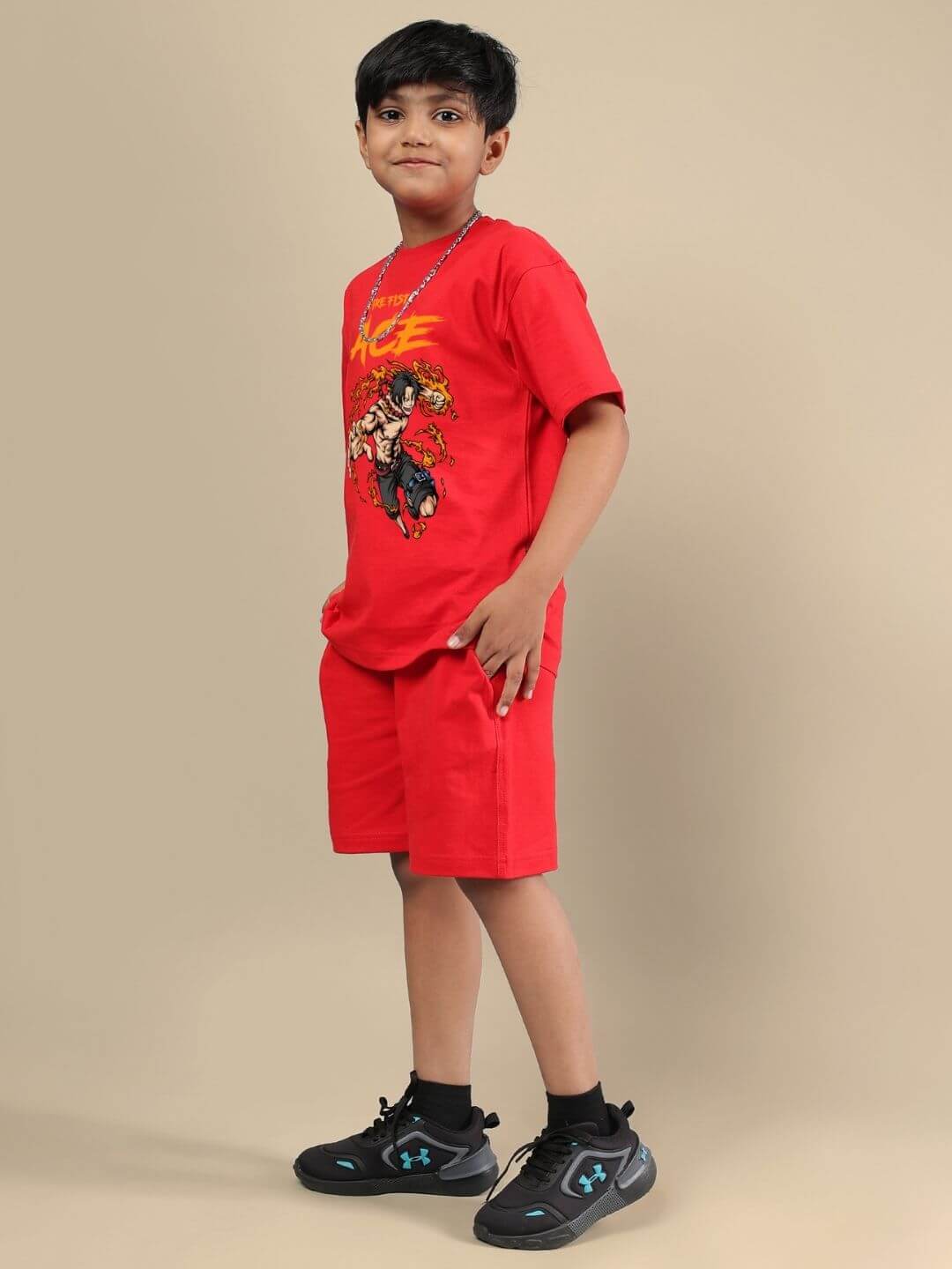 Young child wearing ACE CO-ORD FOR BOYS AND GIRLS RED set featuring vibrant red shorts and a graphic T-shirt, styled with sneakers.