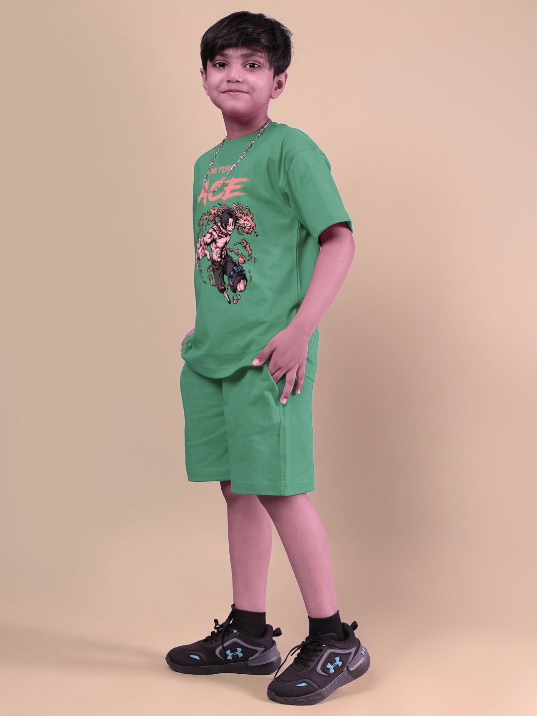 Boy wearing ACE co-ord set in vibrant green, featuring a comfortable matching top and shorts, perfect for kids, against a beige background.