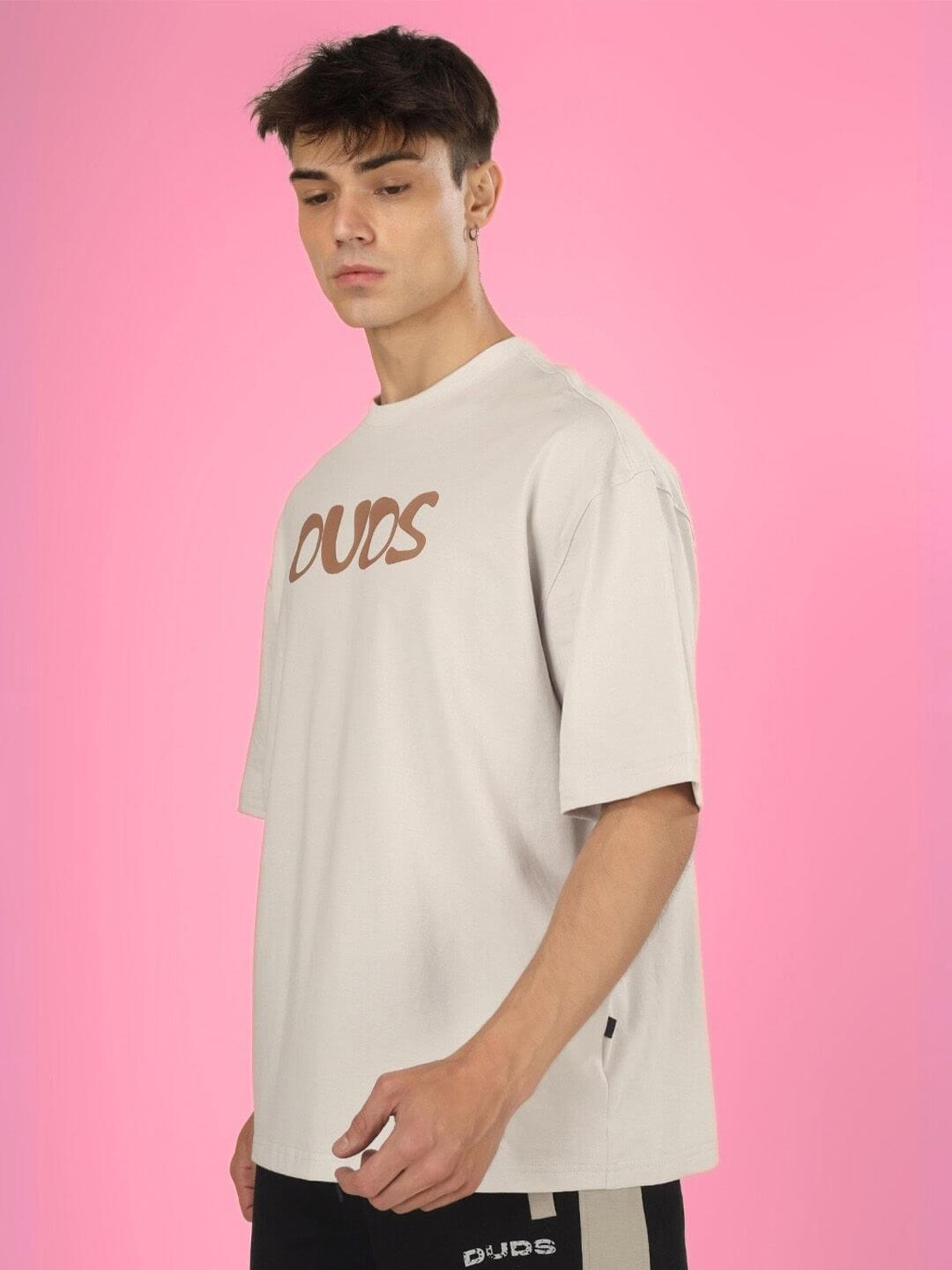 Model wearing HIGH AS FUCK OVER-SIZED T-SHIRT BUTTER CREAM against pink background