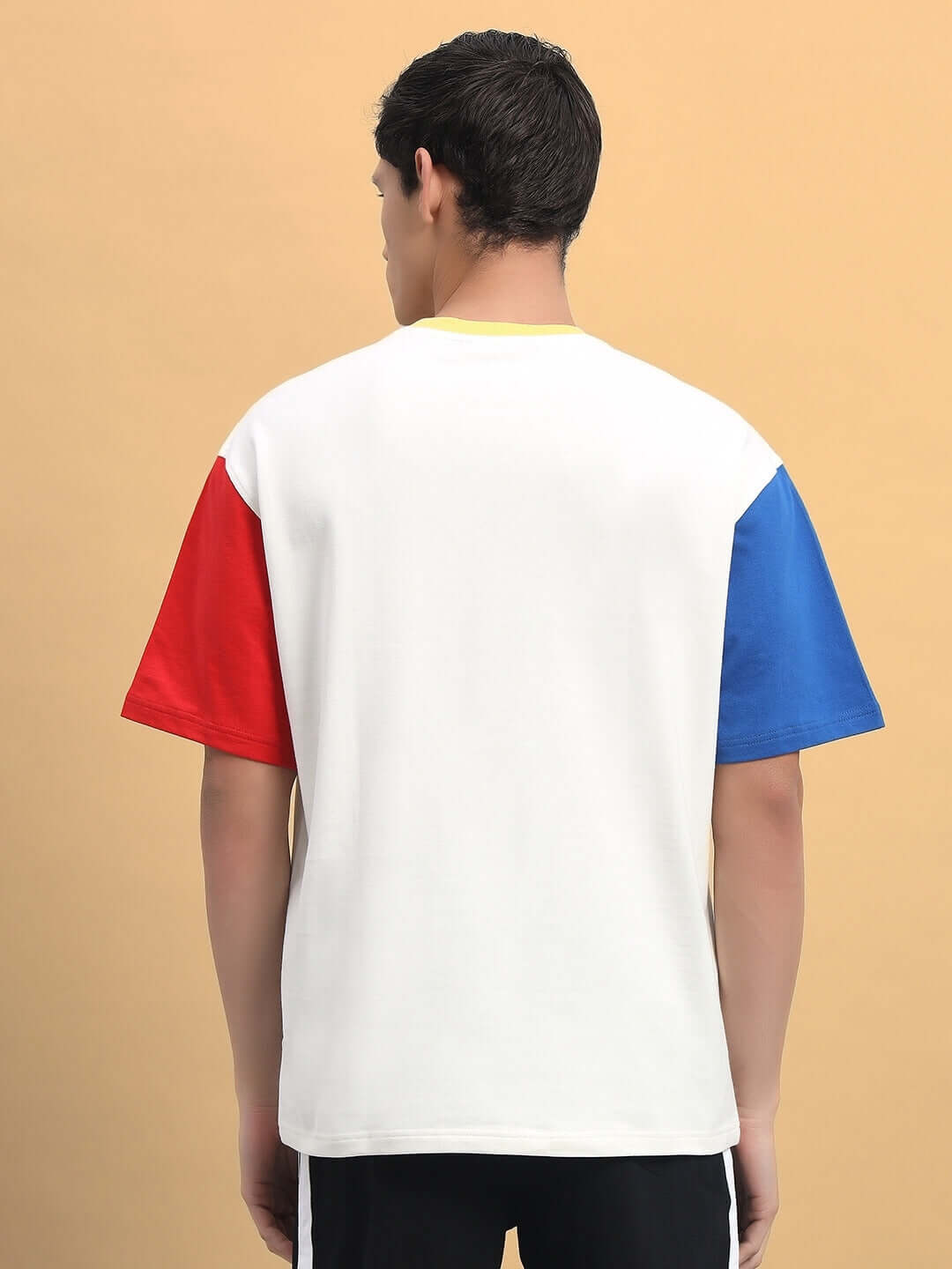 Back view of an ADONIS color blocked oversized T-shirt in off white with red and blue sleeves, made from premium cotton fabric.
