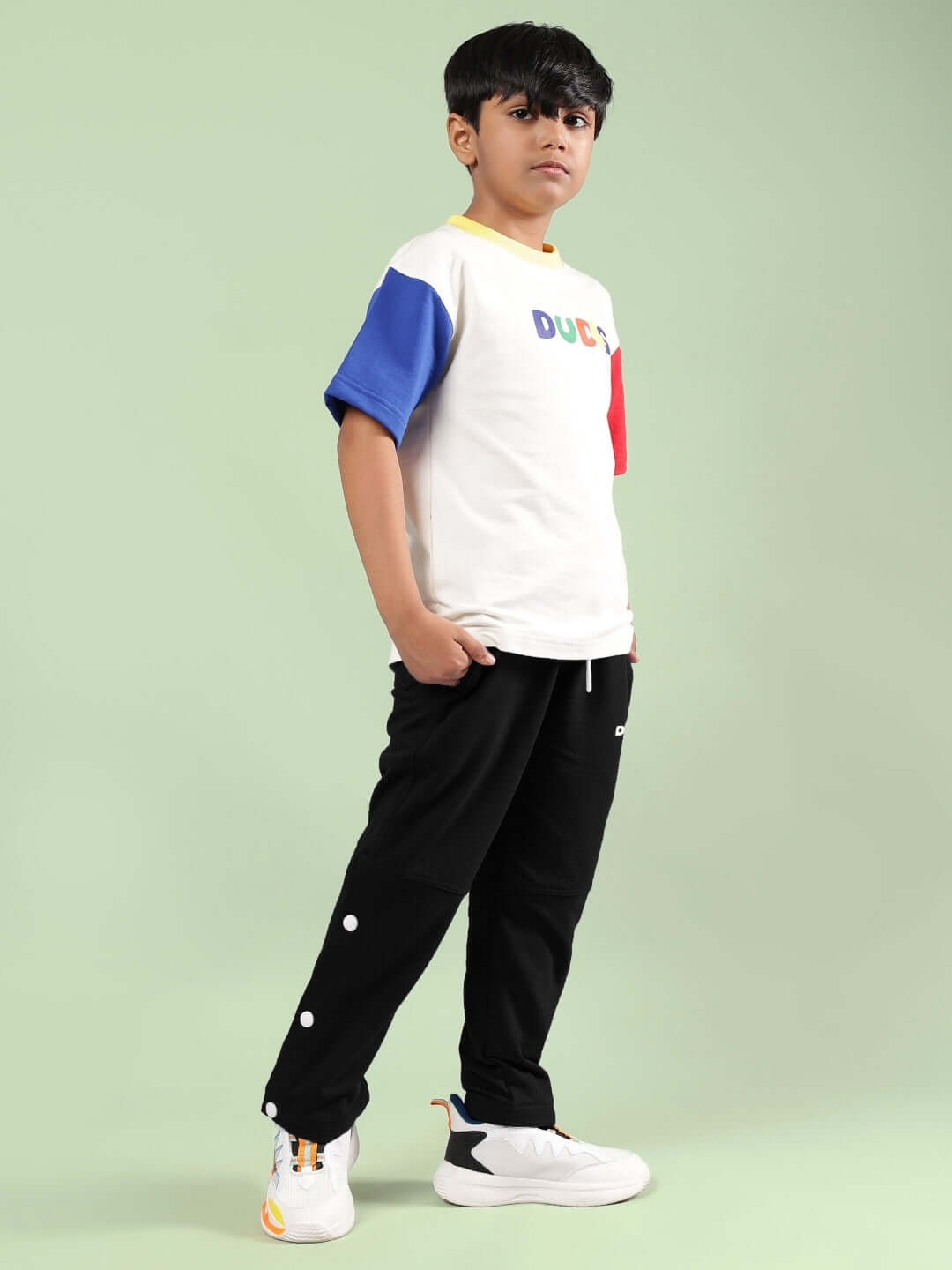 Boy wearing ADONIS CO-ORD FOR BOYS GIRLS OFF WHITE-BLACK set, featuring colorful top and black pants.