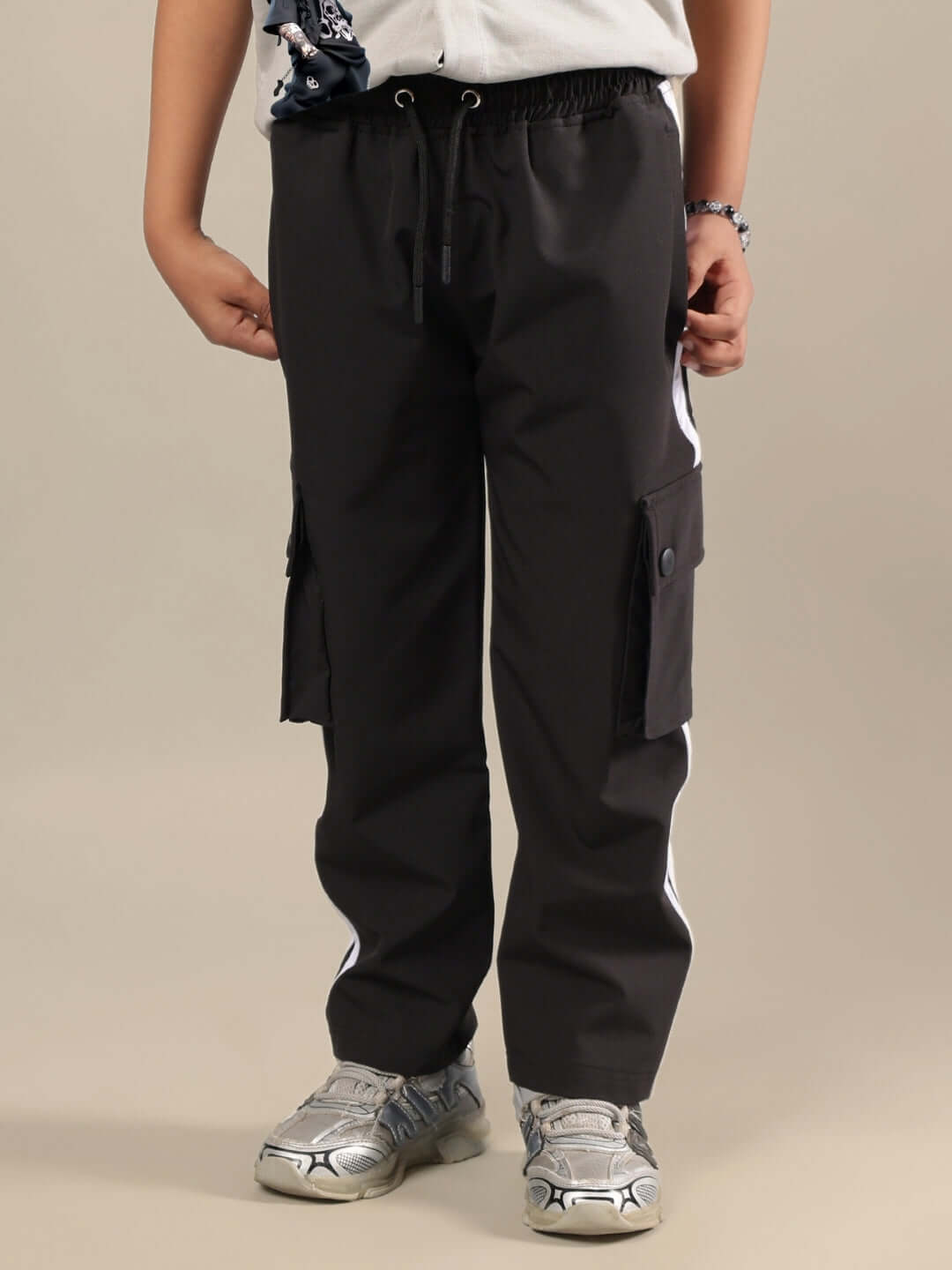 Child wearing grey-black co-ord pants with side pockets, designed for boys and girls by DUDS.