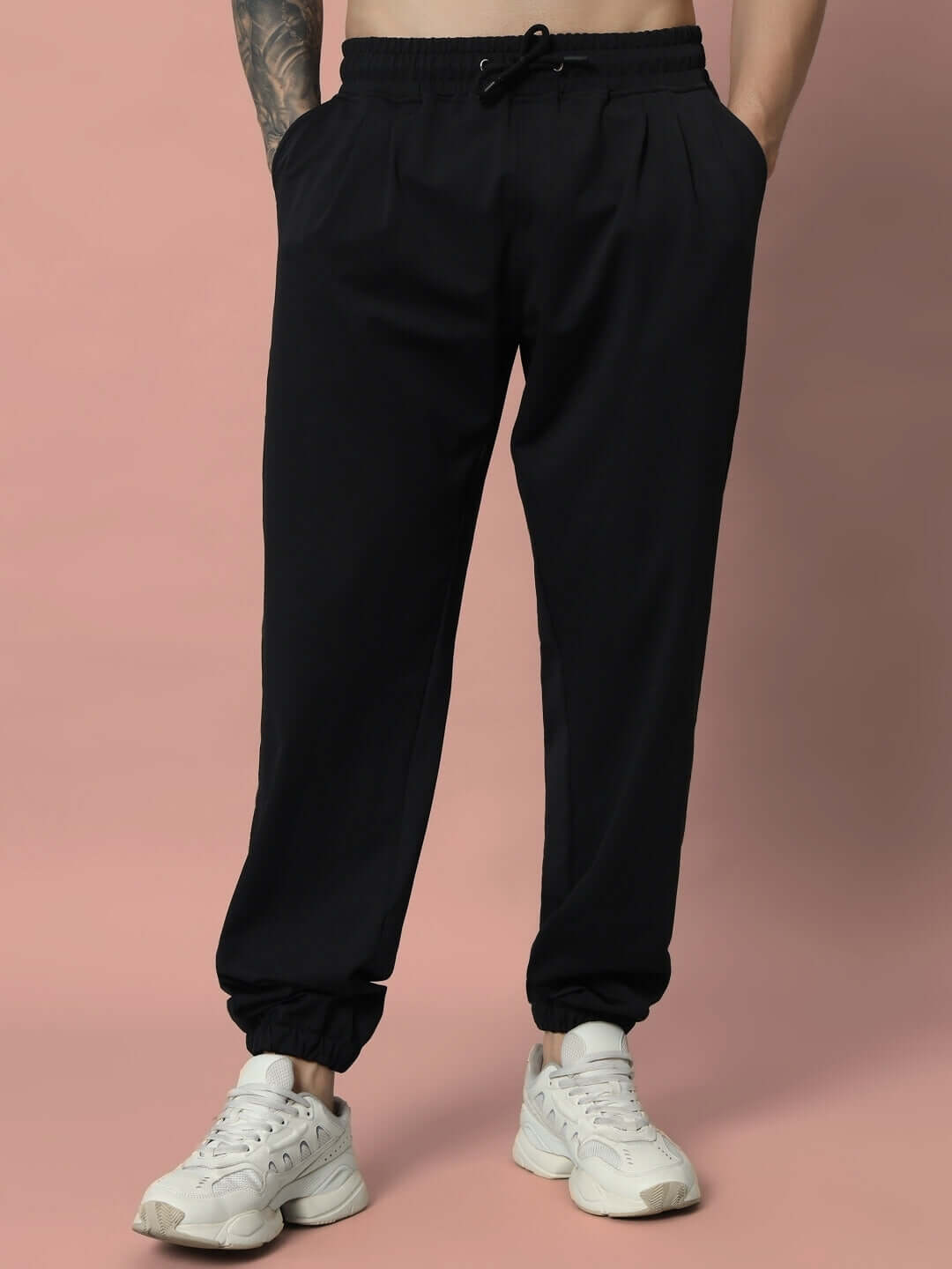 Model wearing Agile Relaxed Pant Jogger in black, featuring an elastic waistband and cuffed ankles, styled with white sneakers.