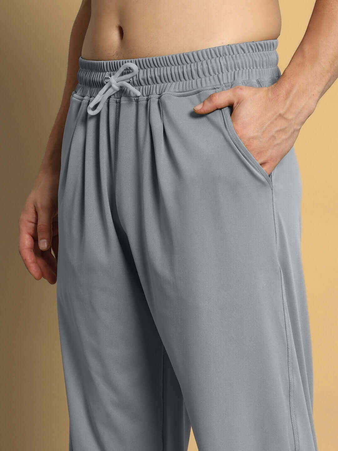 Model wearing grey Agile Relaxed Pant Jogger by DUDS, featuring an elastic waistband and side pockets, ideal for custom fit orders.