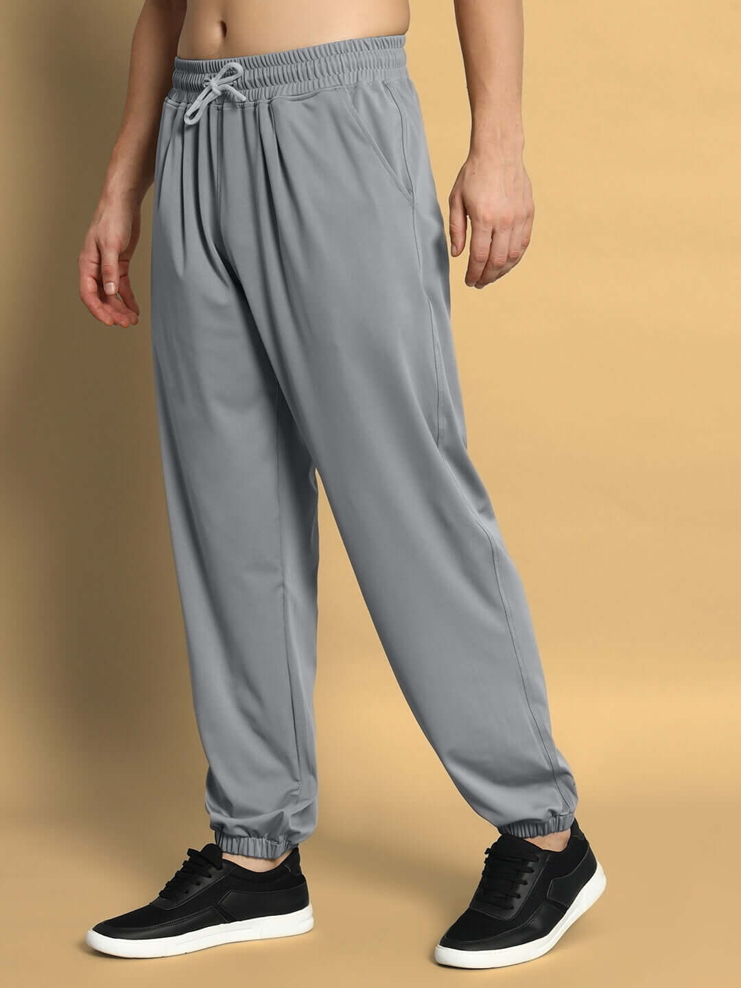 Model wearing grey agile relaxed pant joggers from DUDS, featuring a comfortable fit and customizable size options.