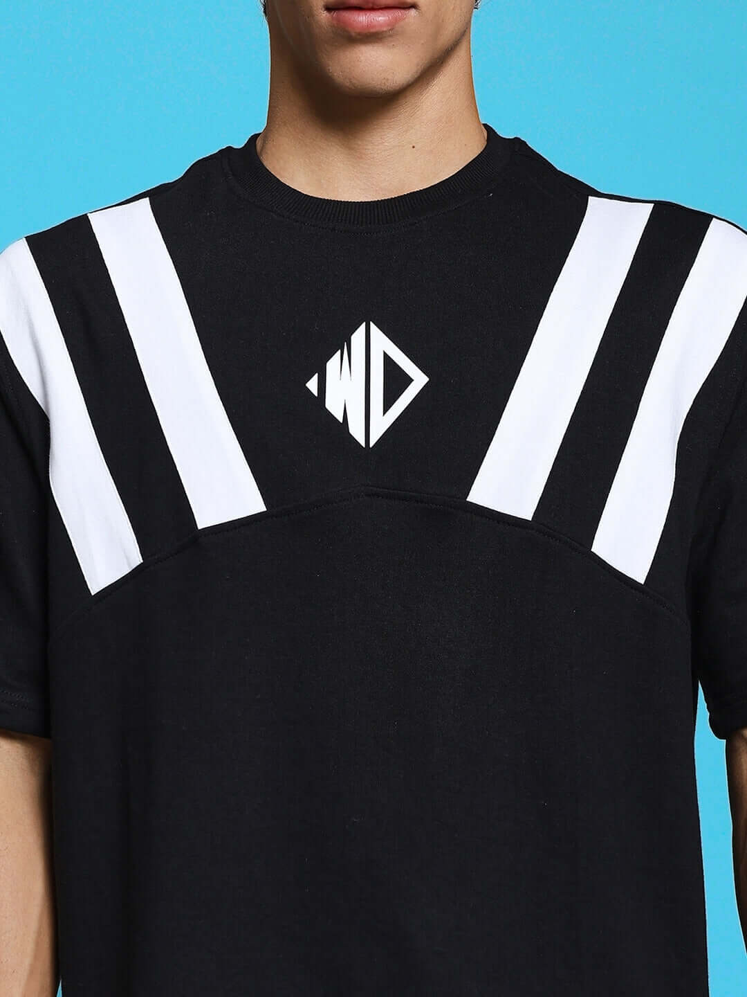 Model wearing Allonzo over-sized black T-shirt with white stripes, made of premium cotton blend, suitable for trendy casual outfits.