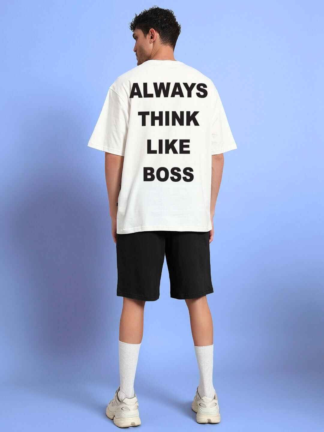 Back view of man wearing off-white T-shirt with 'Always Think Like Boss' text and black shorts, part of THINK BIG BUNNY TOONS co-ord set.