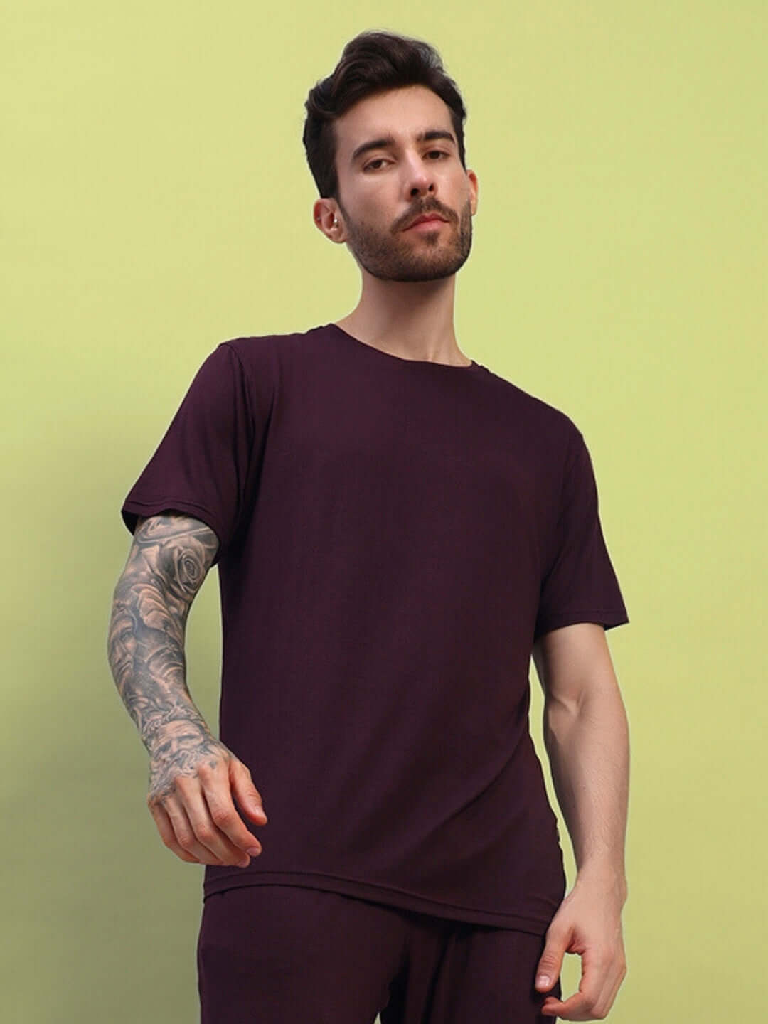 Model wearing AMBLE T-Shirt in maroon, made from premium heavy gauge modal fabric, posed against a lime green background.
