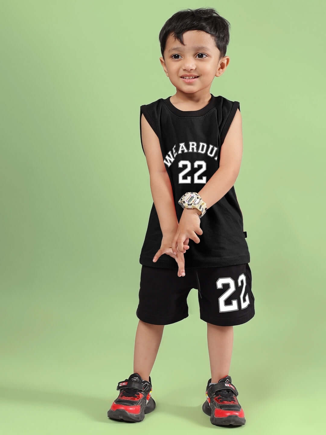 Child wearing black AMIGA CO-ORD FOR BOYS & GIRLS, featuring sleeveless top and matching shorts with number 22 and stylish sneakers.