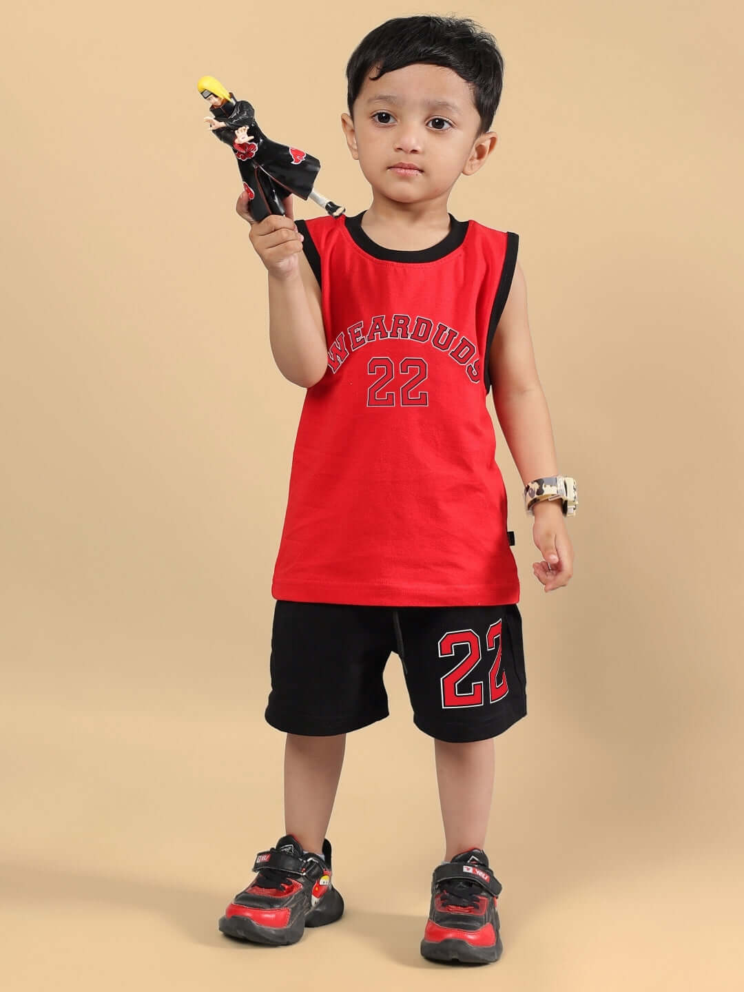 Child wearing red and black Amiga co-ord set holding a toy, highlighting the comfortable fit for boys and girls.
