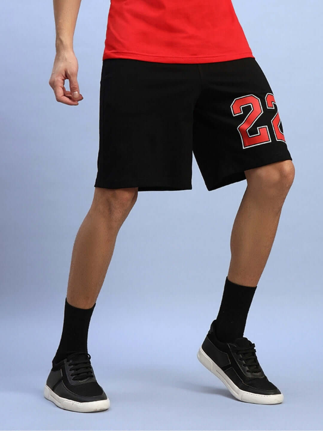 Model wearing AMIGA REGULAR FIT SHORTS BLACK with custom fit option, embroidered number 22, standing in casual style.