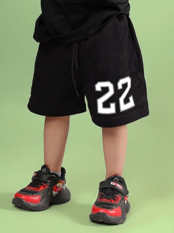 Child wearing black shorts with white number 22, styled for boys and girls, handmade by tailors at DUDS with custom fit option.