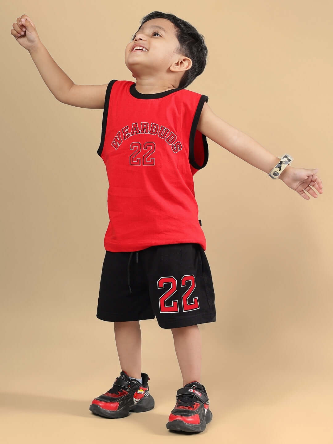 Child wearing AMIGA CO-ORD FOR BOYS & GIRLS RED BLACK set with red top and black shorts, showcasing clothing style.