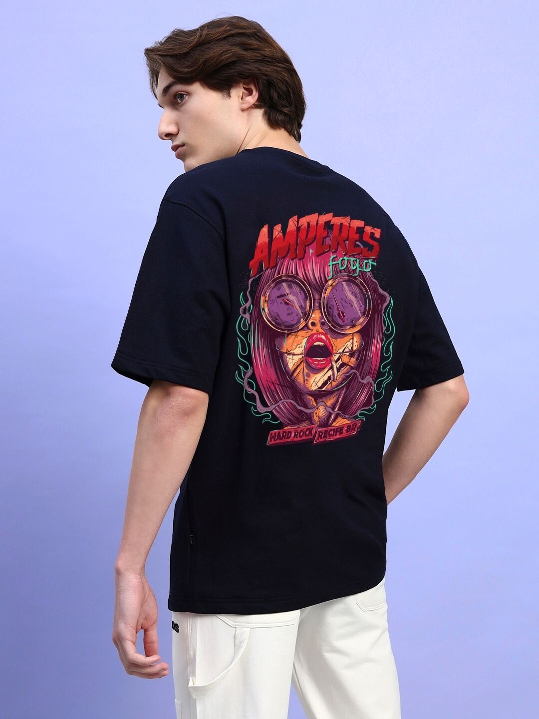 Back view of a model wearing AMPERES PRINT OVERSIZED T-SHIRT BLACK with vibrant graphic design on a purple background.