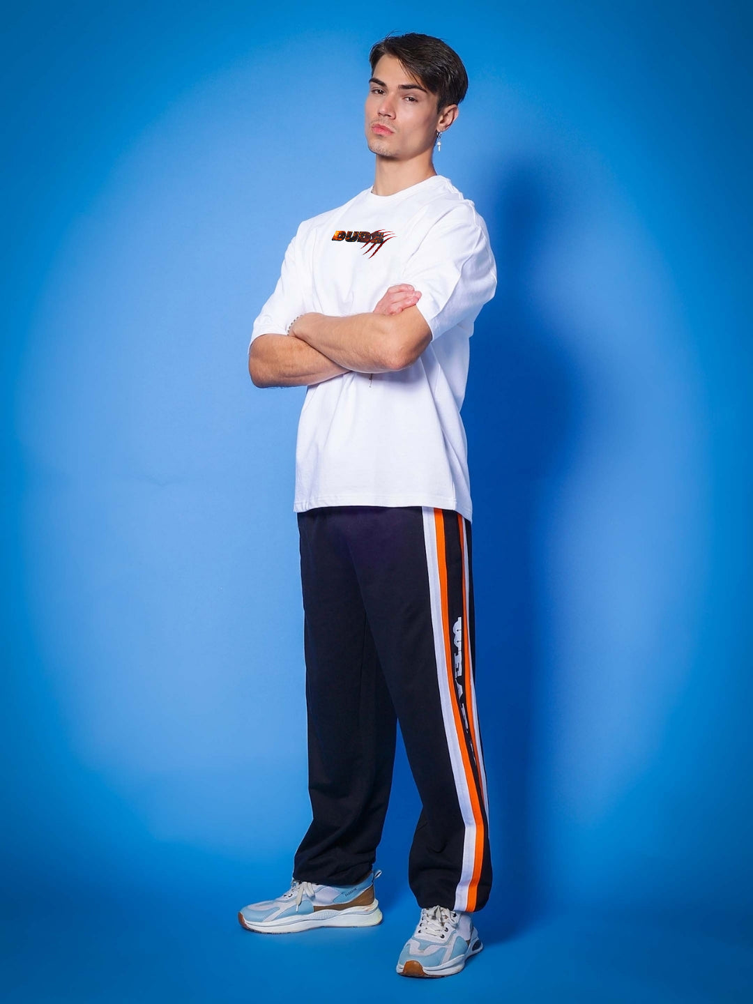 Model wearing ANGRY PANTHER OVERSIZED T-SHIRT WHITE with blue background, showcasing casual fashion style.