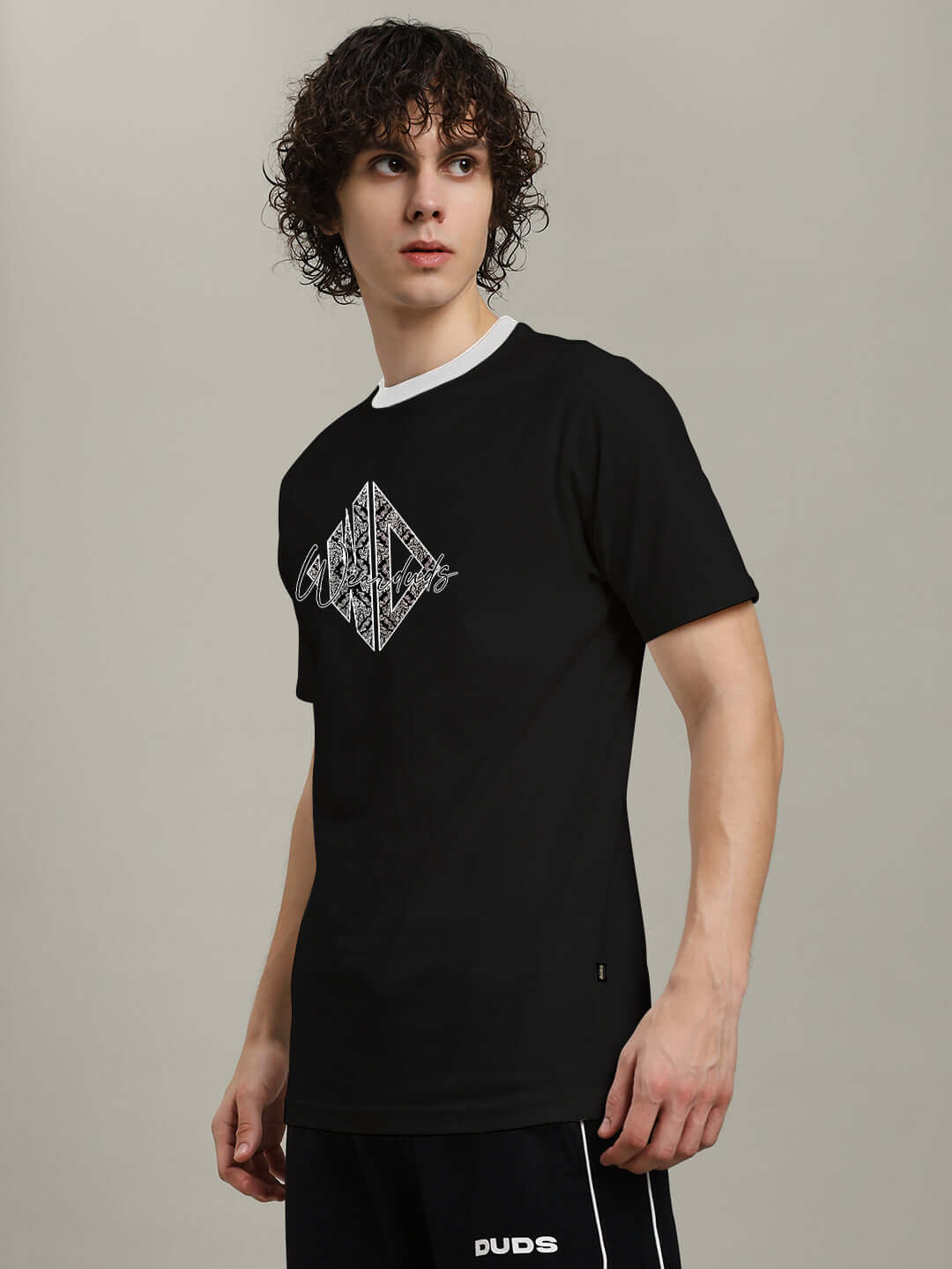 Model wearing ANGULAR REGULAR FIT T-SHIRT BLACK with unique angular graphic, showcasing comfortable and stylish casual wear for all body types.