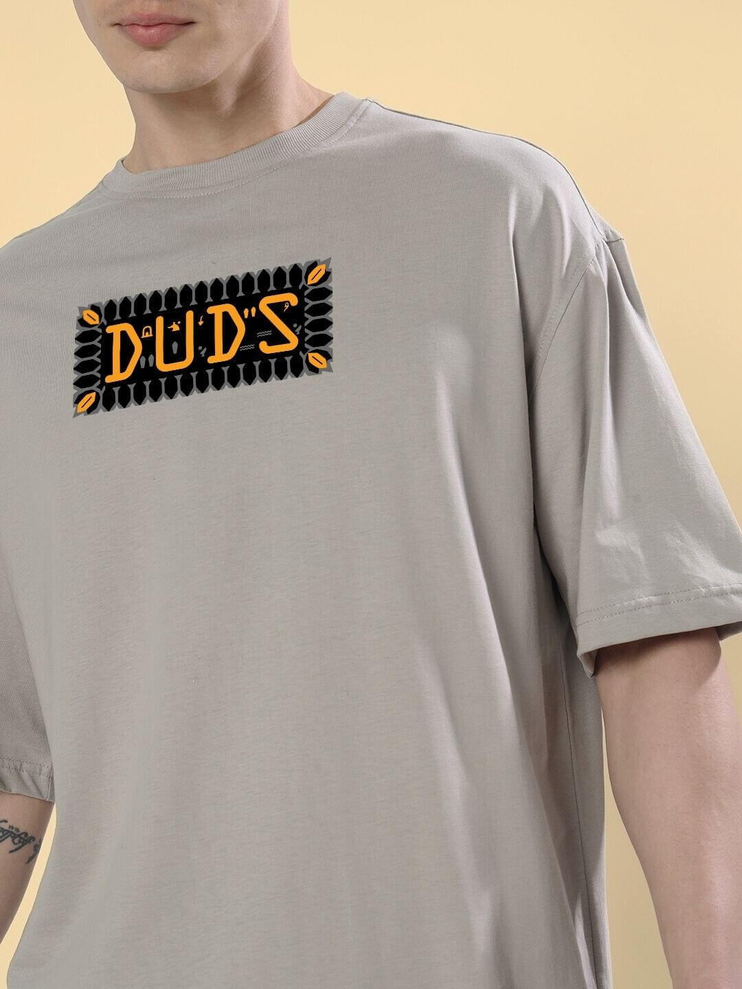 Person wearing ANUBIS EGYPTIAN PRINTED OVERSIZED T-SHIRT GREY, featuring detailed Anubis artwork in a soft grey color scheme.