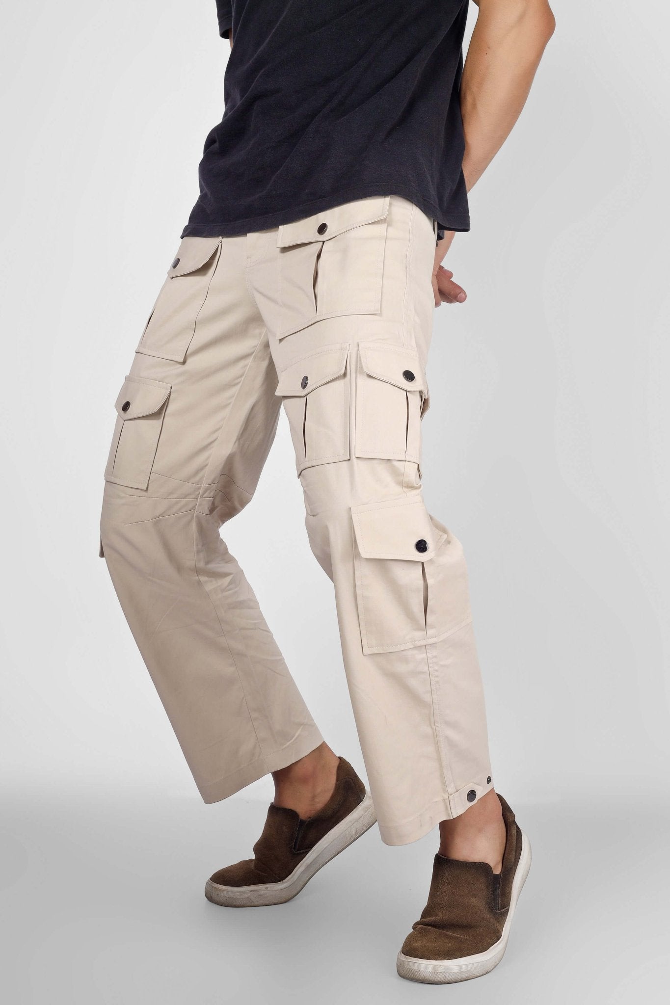 Person wearing ARCADIA WHITE 14 POCKET CARGO PANTS showcasing functional utility in sleek, modern design with multiple pockets.