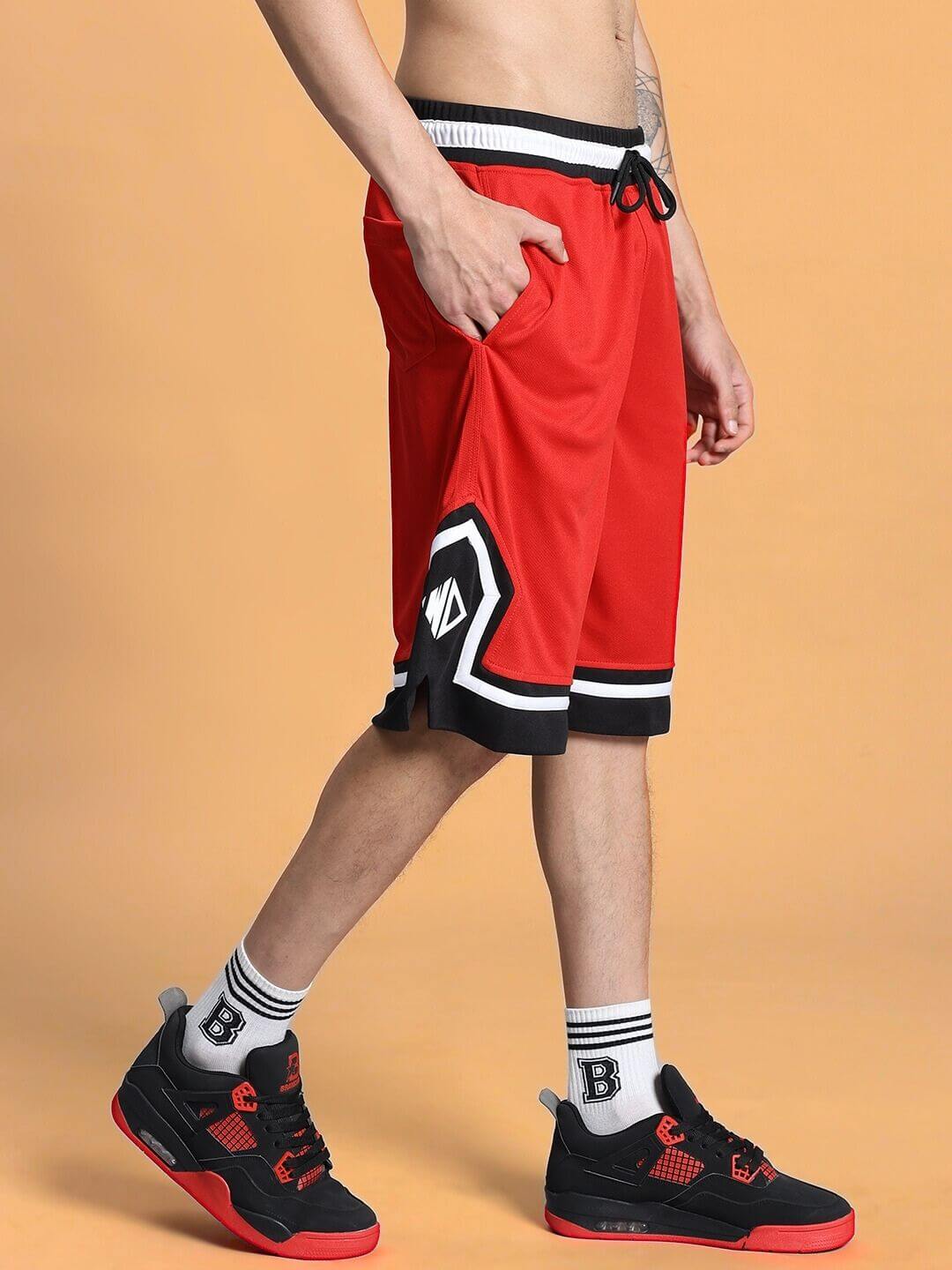 Man wearing ARMADO regular fit red shorts with side pockets, showcasing a sporty look. Perfect for casual and athletic wear.