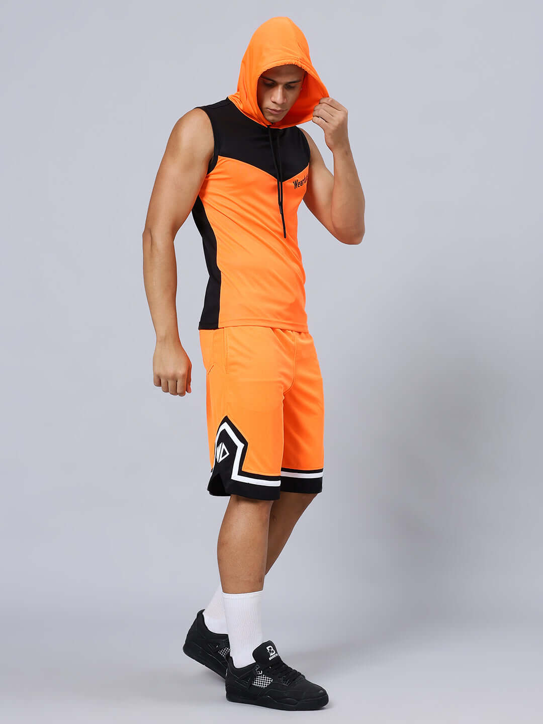 ARMADO REGULAR FIT SHORTS ORANGE BLACK Model wearing ARMADO Regular Fit Orange Black Shorts and matching top, perfect for a sporty look.
