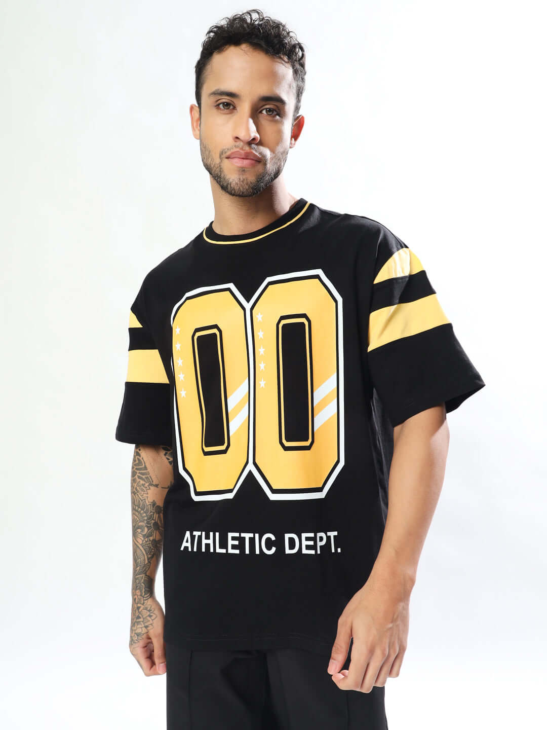 Athletic oversized t-shirt in black and yellow, featuring sporty graphics, made from premium cotton blend, worn by a model.
