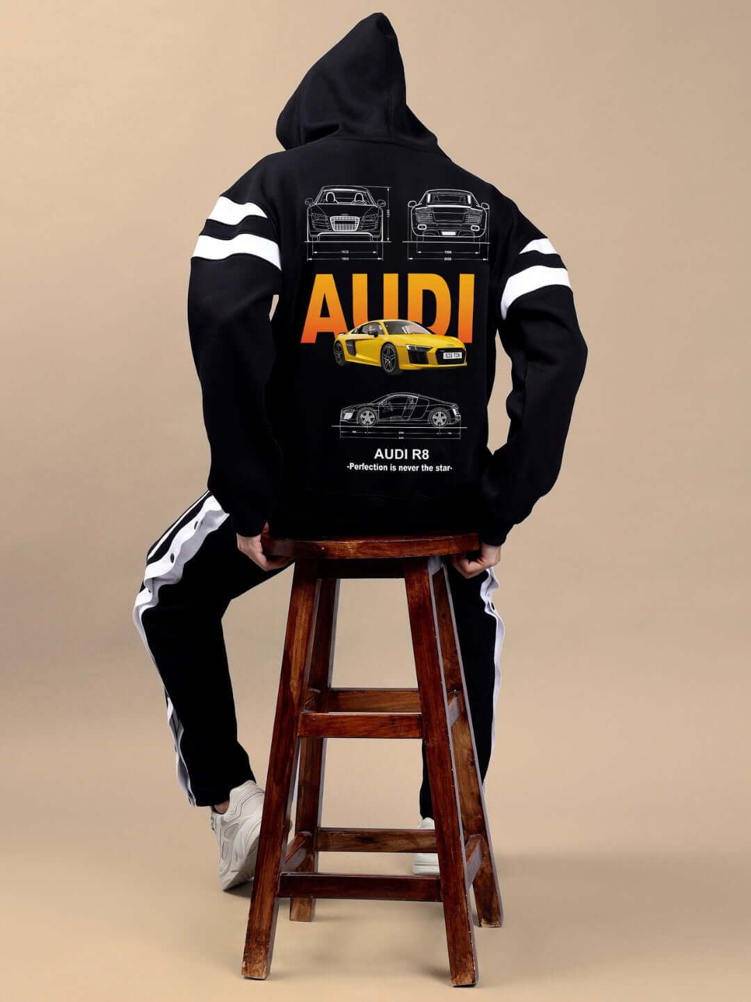 Back view of AUDI R8 FLEECE COLORBLOCK OVERSIZE HOODIE BLACK showcasing car graphics on a seated model.