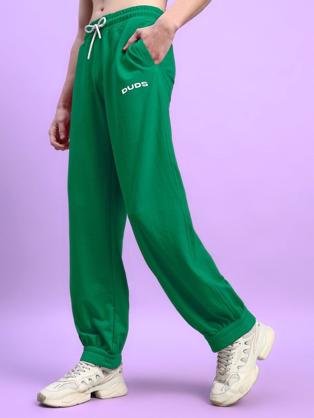 Person wearing green Austrian relaxed-fit joggers by DUDS, featuring casual style with adjustable waist for custom fit options.