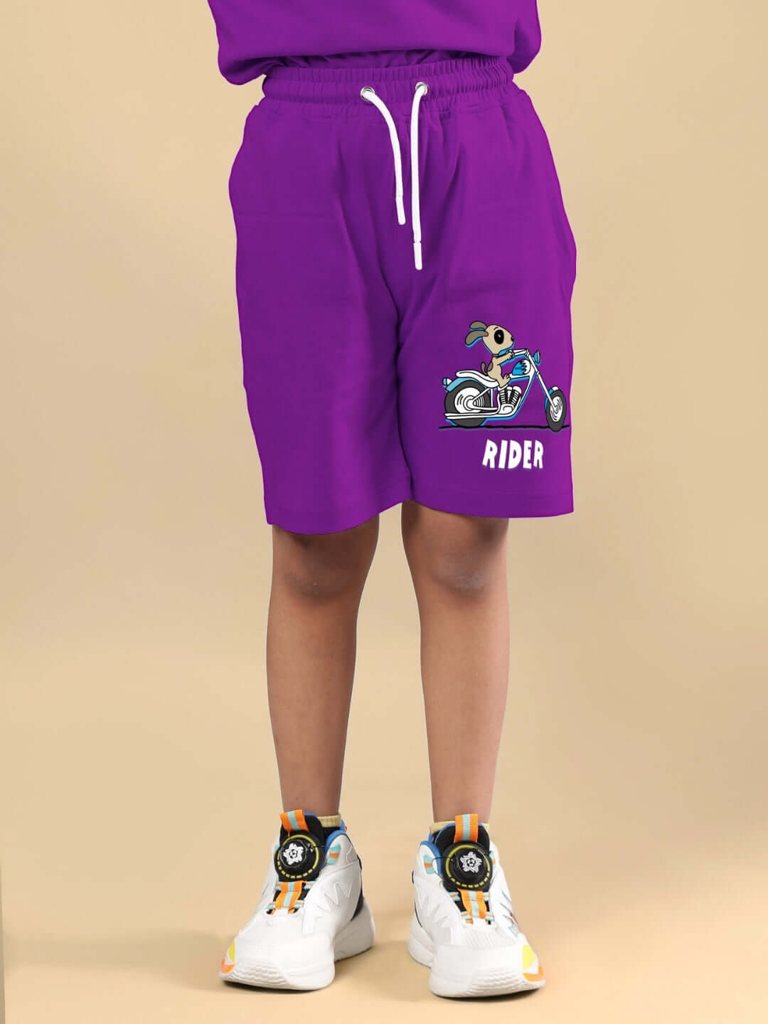 Boy wearing purple authentic rider shorts with motorcycle graphic, suitable for boys and girls, showcasing comfortable fit and style by DUDS.