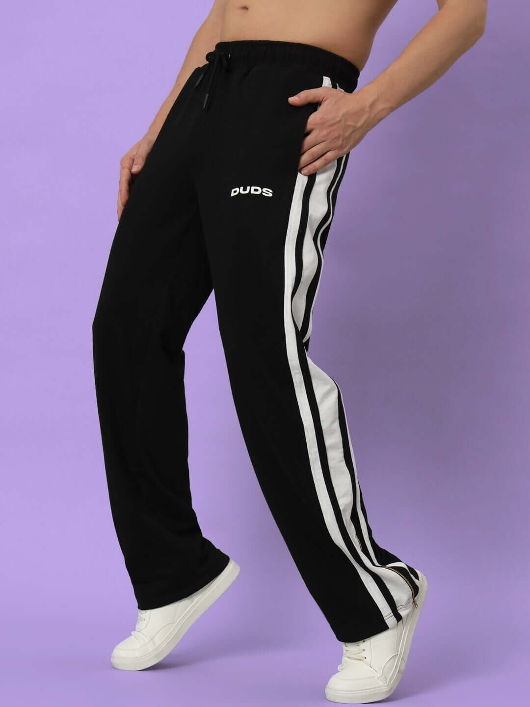 Model wearing AVALON SLIT ZIPPER JOGGERS in black and white, featuring side stripes and DUDS logo, showcasing athletic fit.