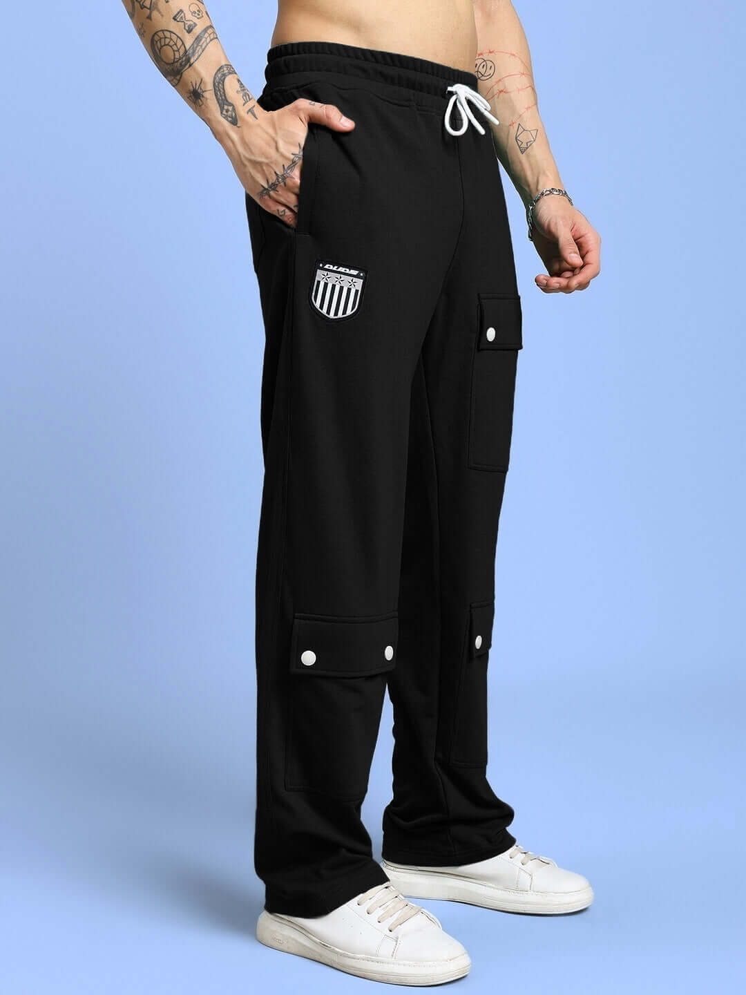 Man wearing black Awesome Flap Pocket Baggy Joggers by DUDS, featuring large pockets and a sporty design.
