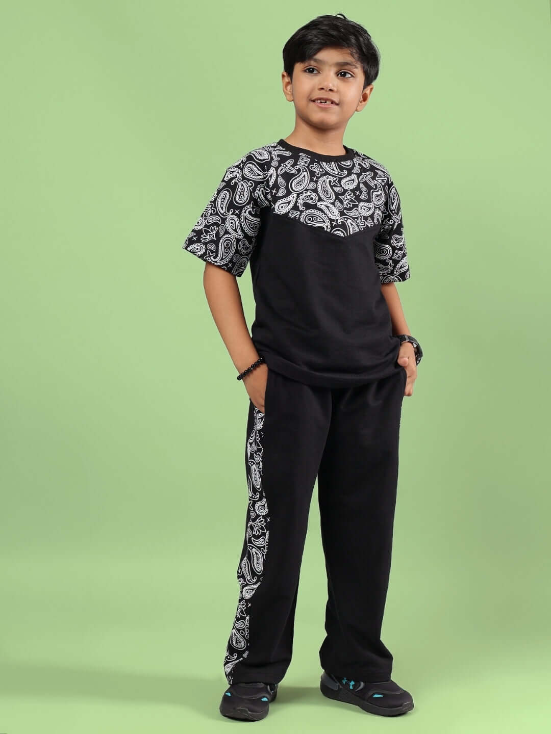 Boy wearing BALADEER CO-ORD FOR BOYS & GIRLS BLACK, showcasing stylish and comfortable kids' fashion against a green background.