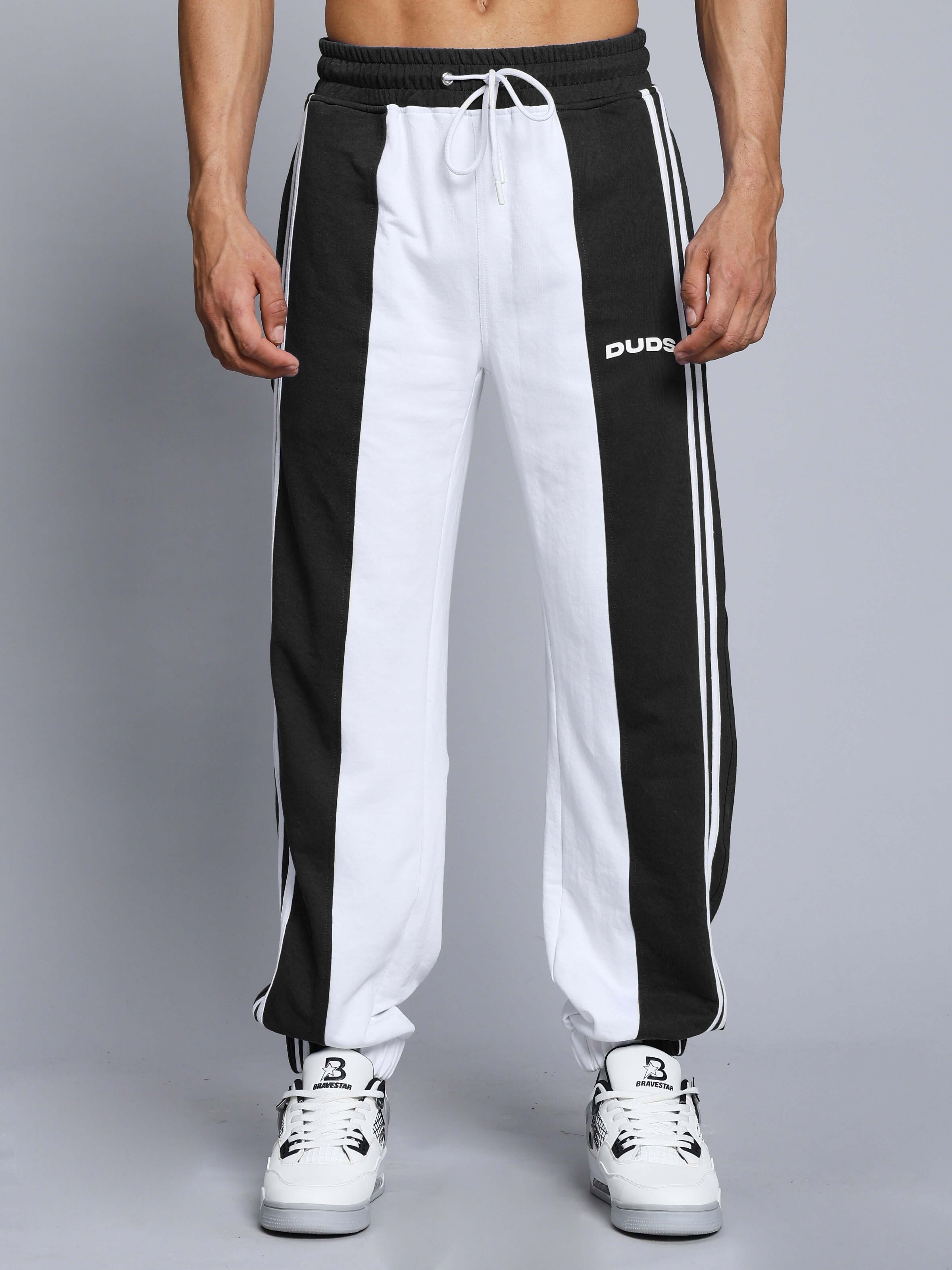 Model wearing BALMY relaxed fit jogger in white and black, tailored by DUDS, showcasing sporty and stylish design with comfort.