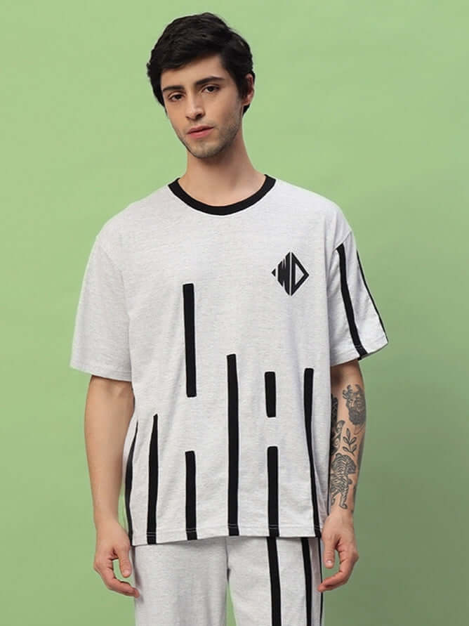 Model wearing Bastille oversized melange grey t-shirt made from premium cotton French terry, showcasing black geometric accents.