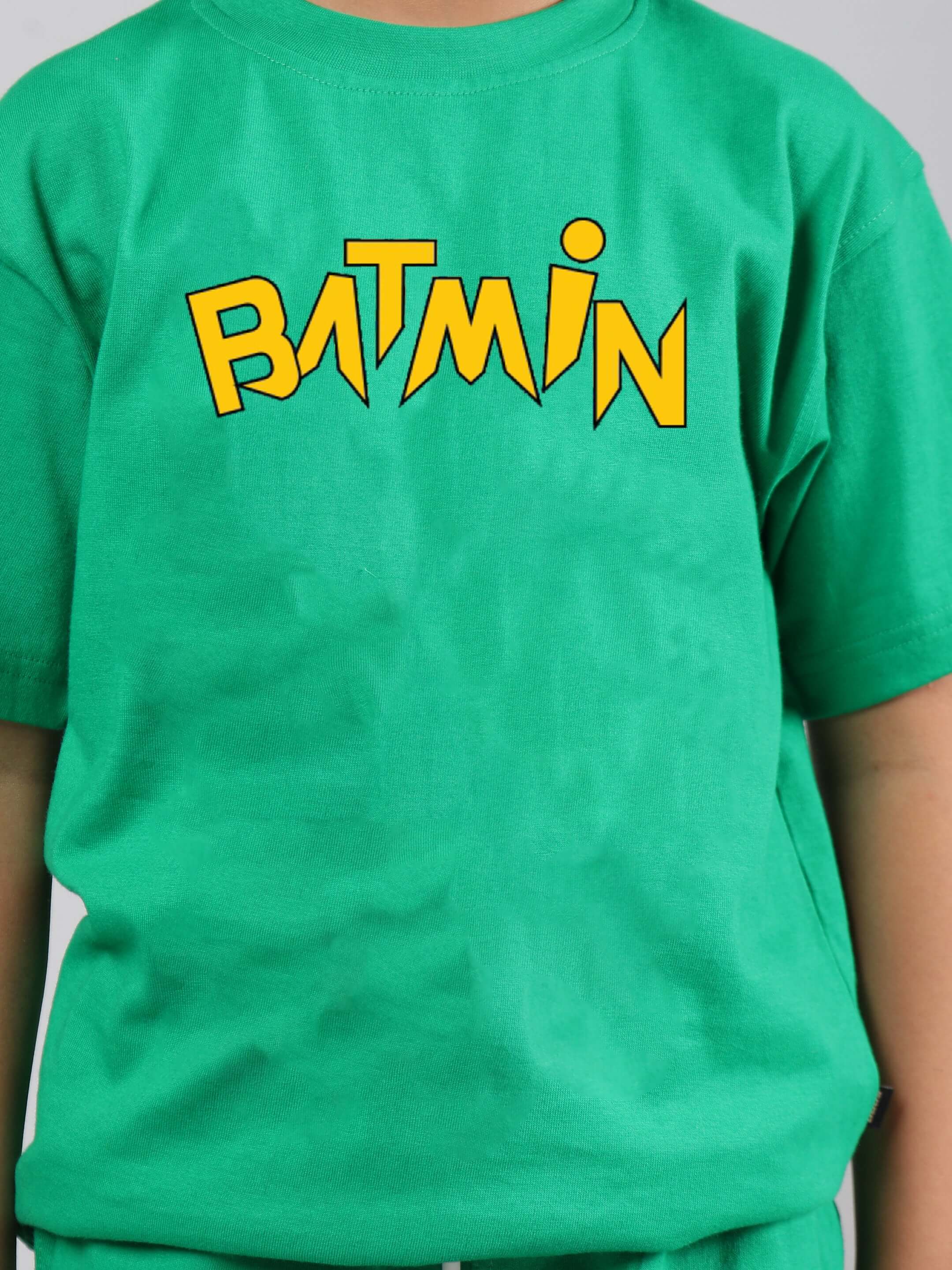 Child wearing green BATMIN CO-ORD FOR BOYS GIRLS GREEN with yellow Batmin logo.