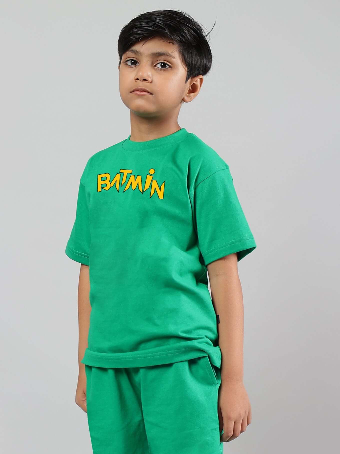Child wearing green Batmin t-shirt for boys & girls with bold graphic print, made from 200 GSM cotton fabric.
