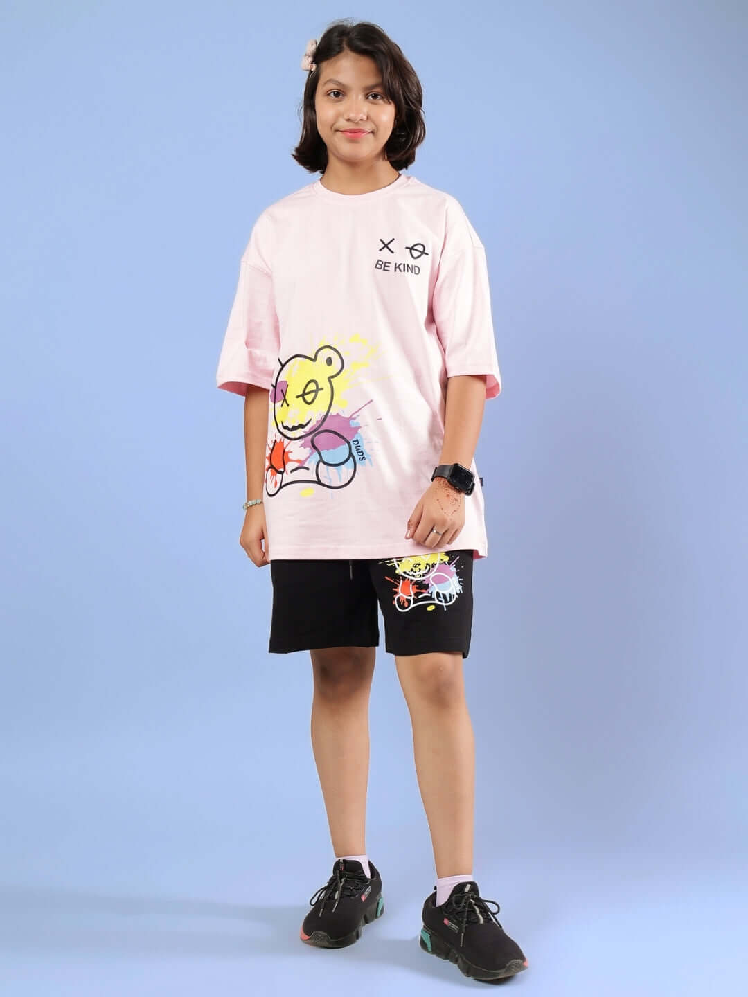 Child wearing unisex BE KIND pink-black co-ord set with teddy design, made by DUDS, showcasing customizable kids clothing.