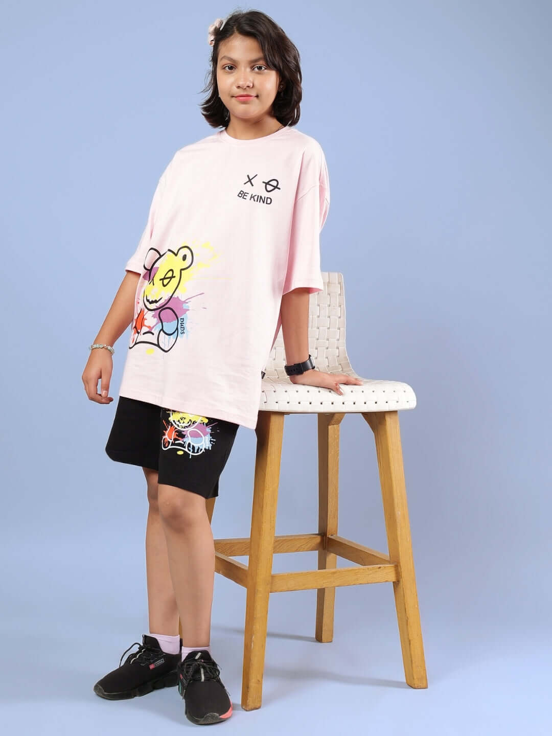 Child wearing BE KIND CO-ORD set for boys & girls in pink and black, standing by a chair, showcasing casual style and comfort.